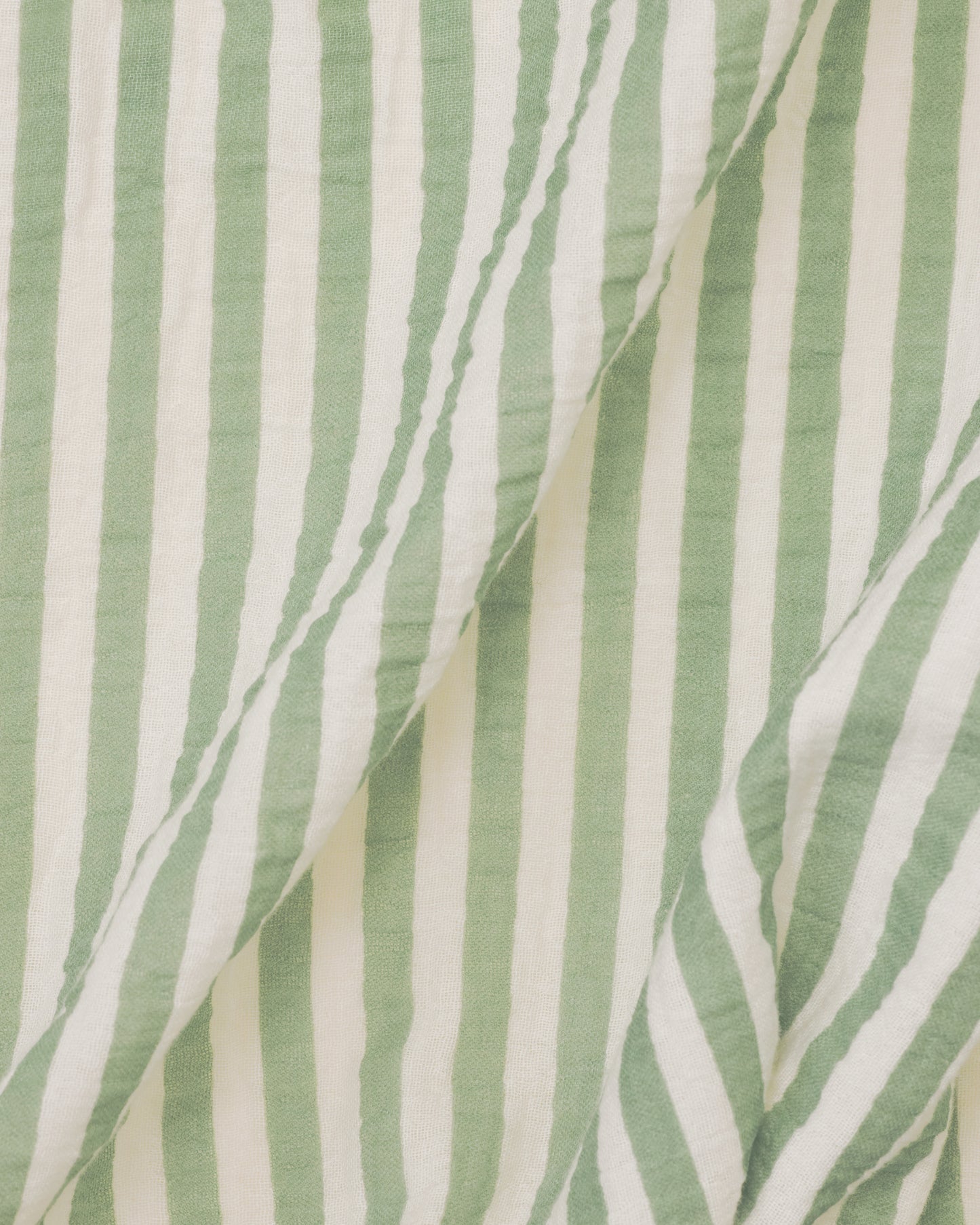 Close up of the Organic Muslin Swaddle in the Sage Stripe print.