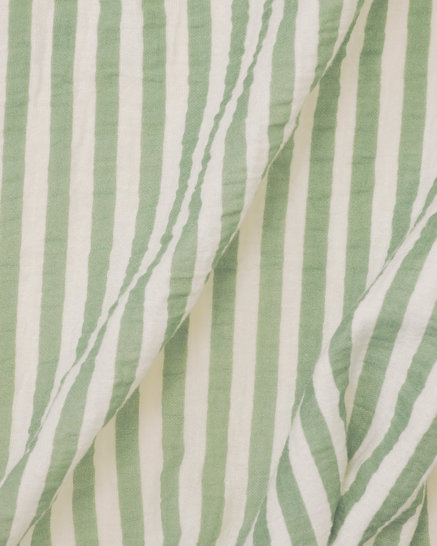 Close up of the Organic Muslin Swaddle in the Sage Stripe print.