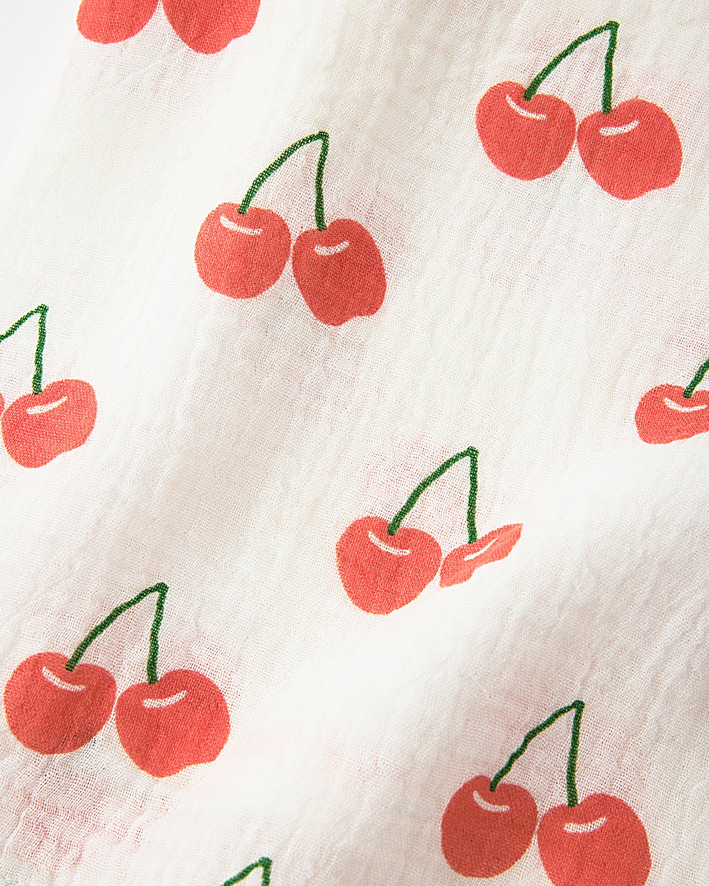Close up of the Must-Have Muslin Set in White Cherries pattern.