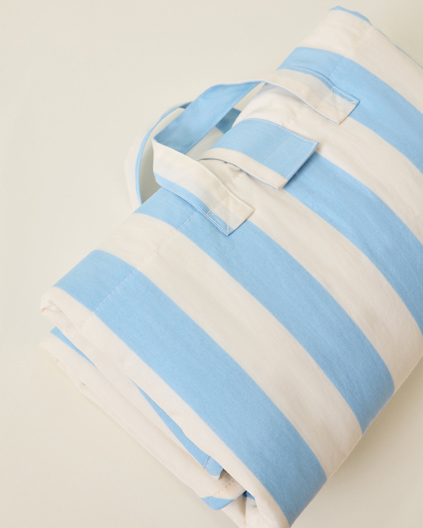 Inside/Outside Play Mat in Blue Wide Stripe detail view on a beige background