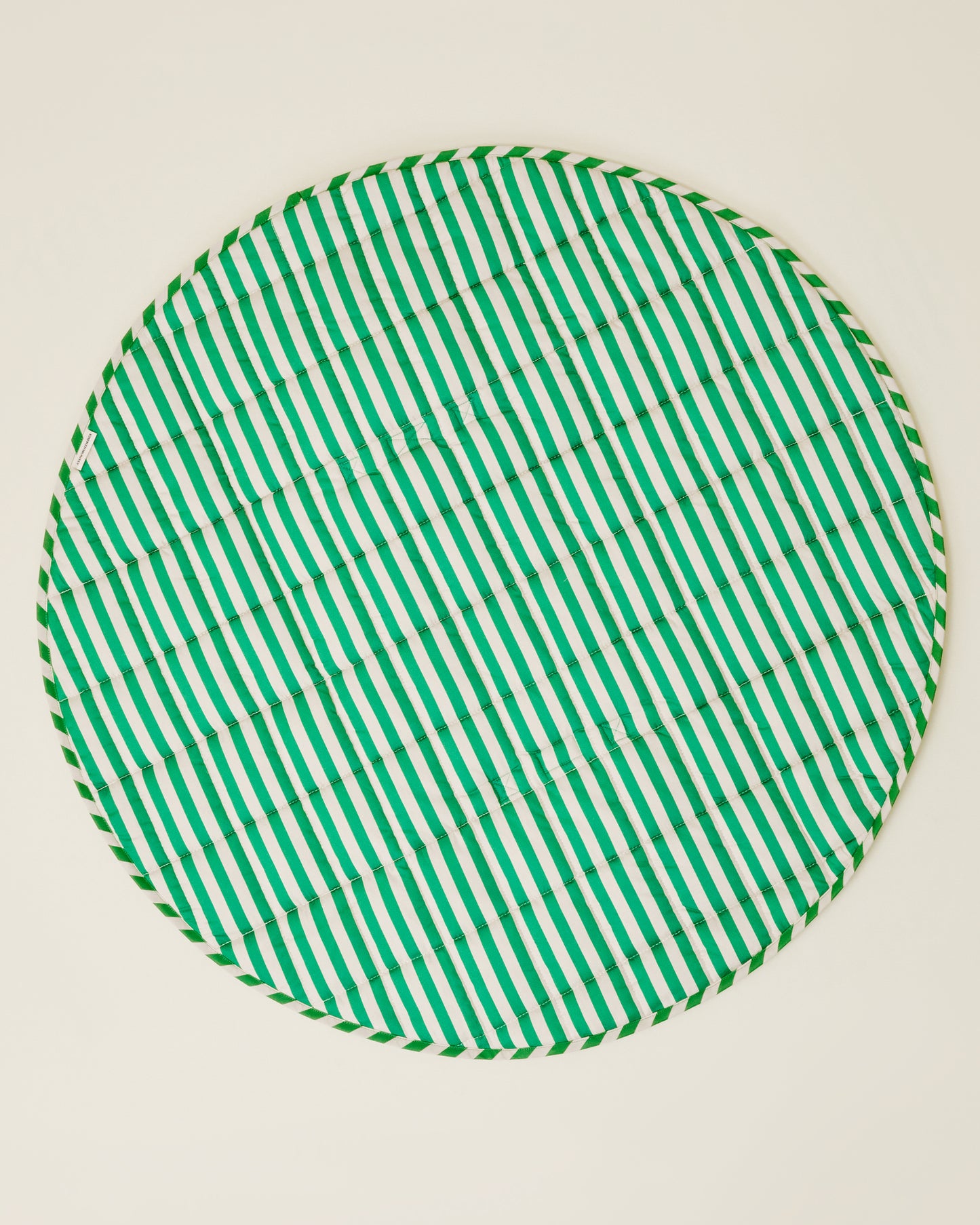 The Inside/Outside Play Mat in Green Stripe print, opened fully to a circle.