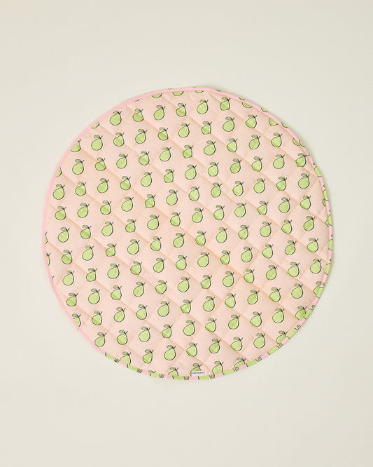 Round pink play mat with green pomelo pattern on a beige background