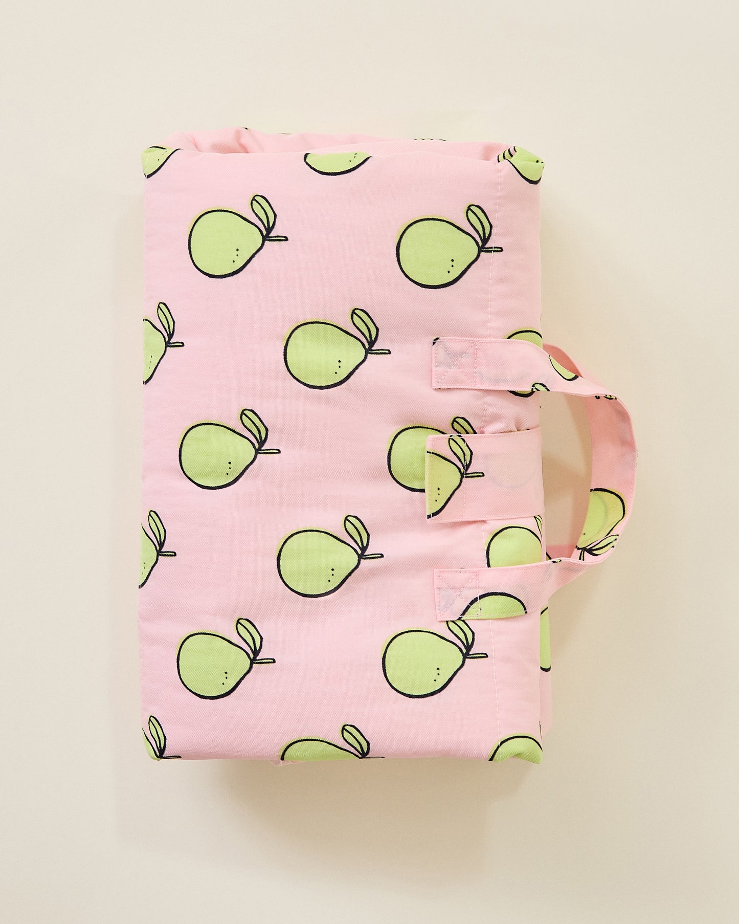 Inside/Outside Play Mat in Pink Pomelo Pattern, folded into a neat rectangle with a handle on a beige background