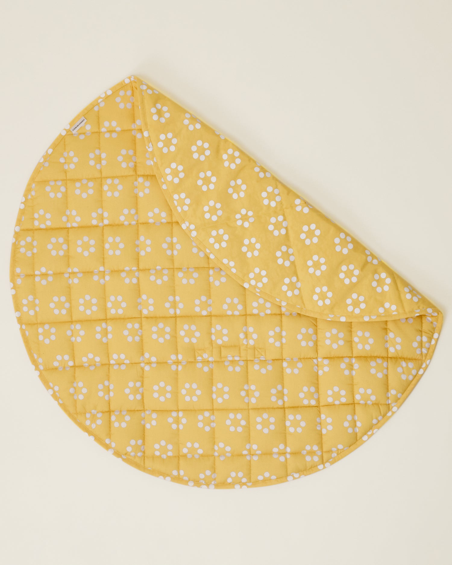 The Inside/Outside Play Mat in Sunshine Dots print, partly folded to display the two sides of the mat.