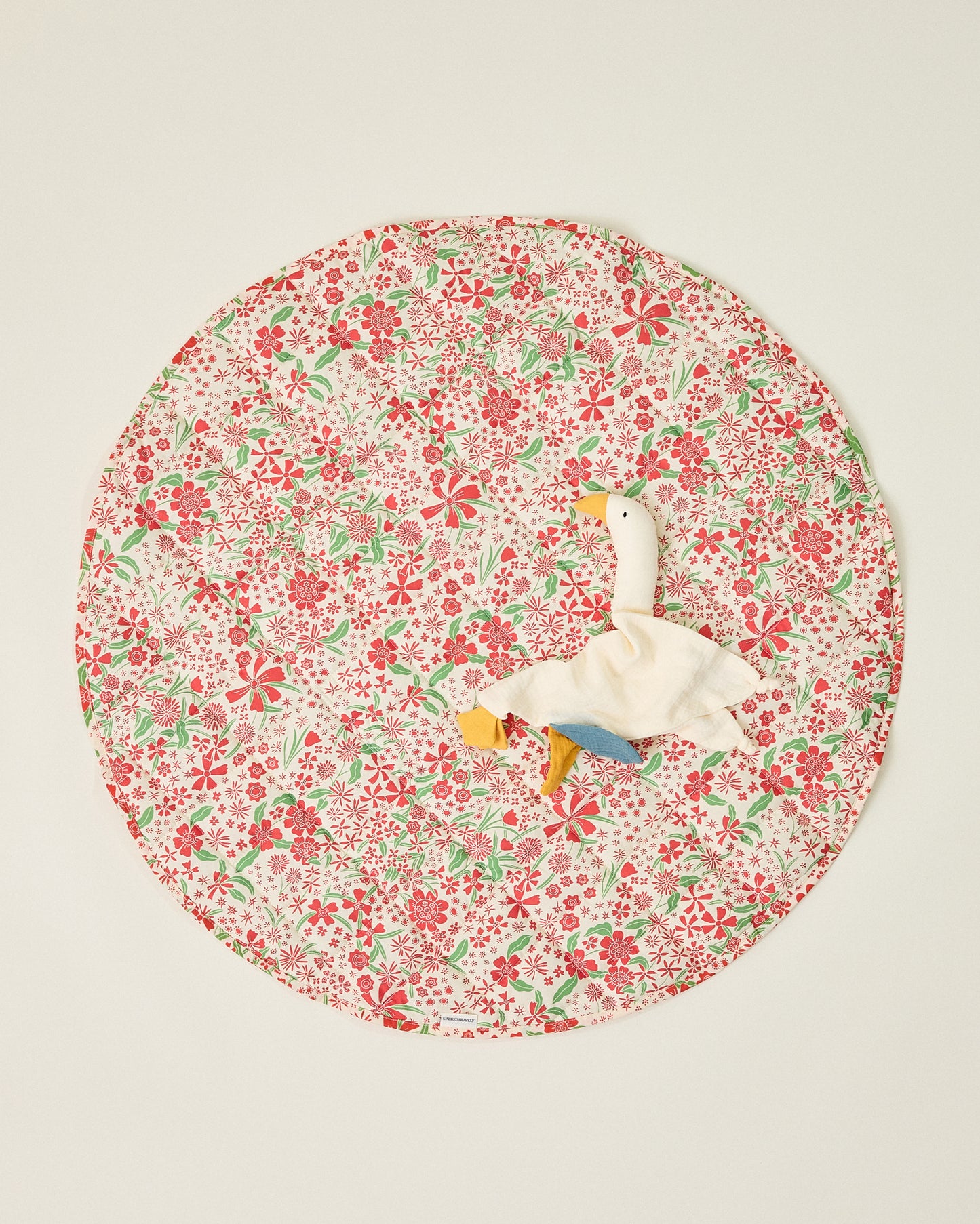 Inside/Outside Play Mat in Superbloom print, with a duck lovey resting ontop, on a beige background