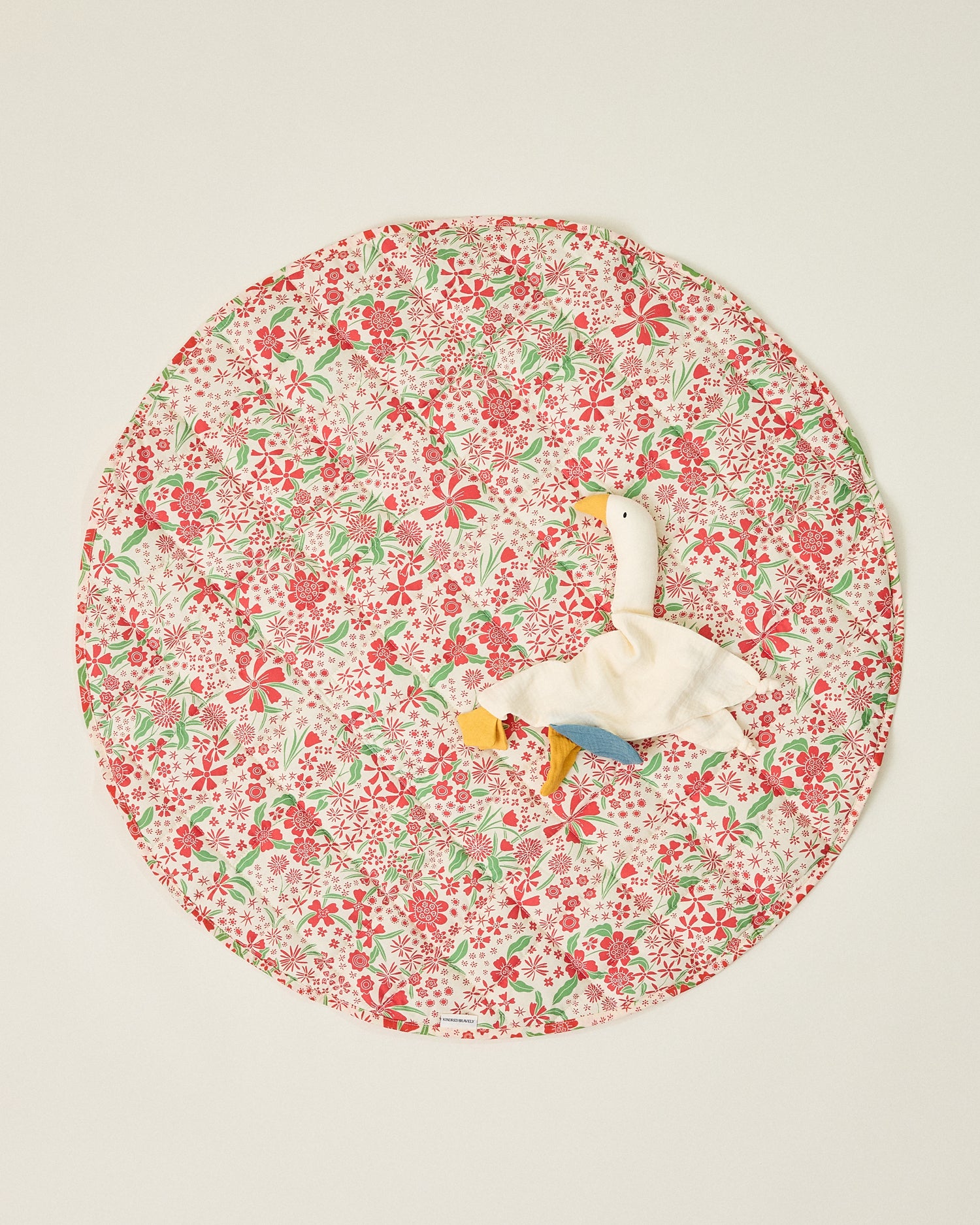 Inside/Outside Play Mat in Superbloom print, with a duck lovey resting ontop, on a beige background