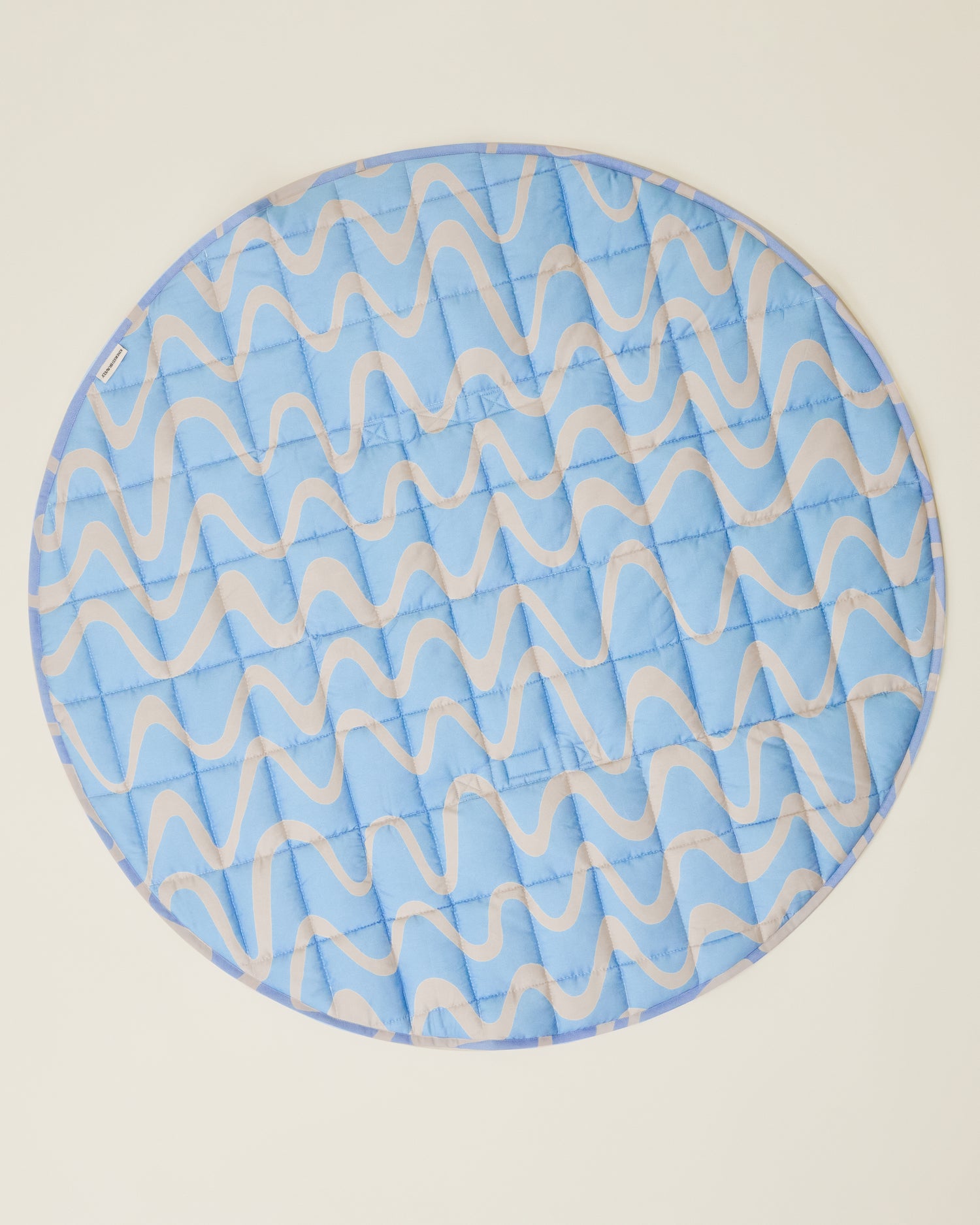 The Inside/Outside Play Mat in Blue Waves print, opened fully to a circle.