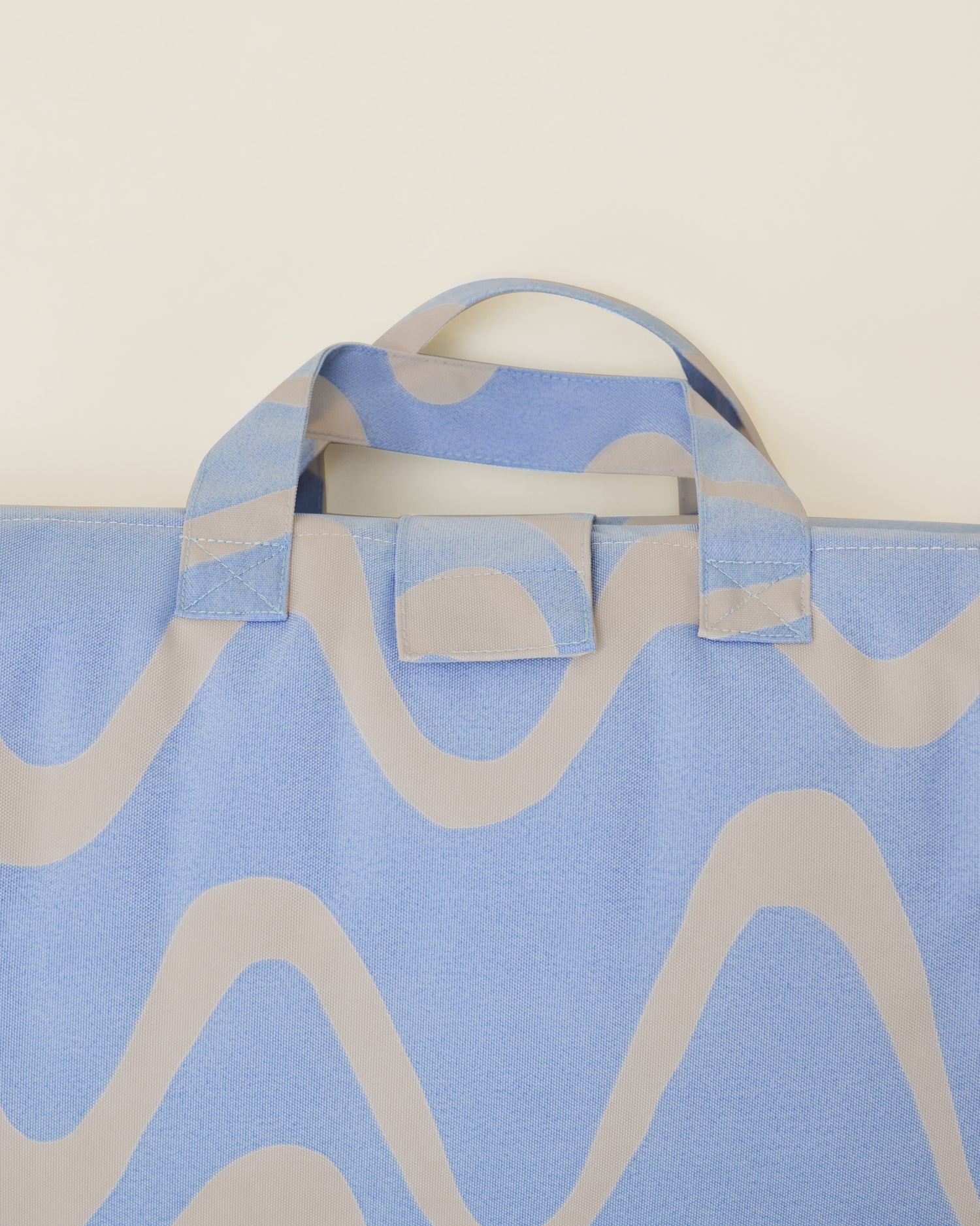 Close up of the Inside/Outside Play Mat in Blue Waves print, showing the detail of the inbuilt handle.