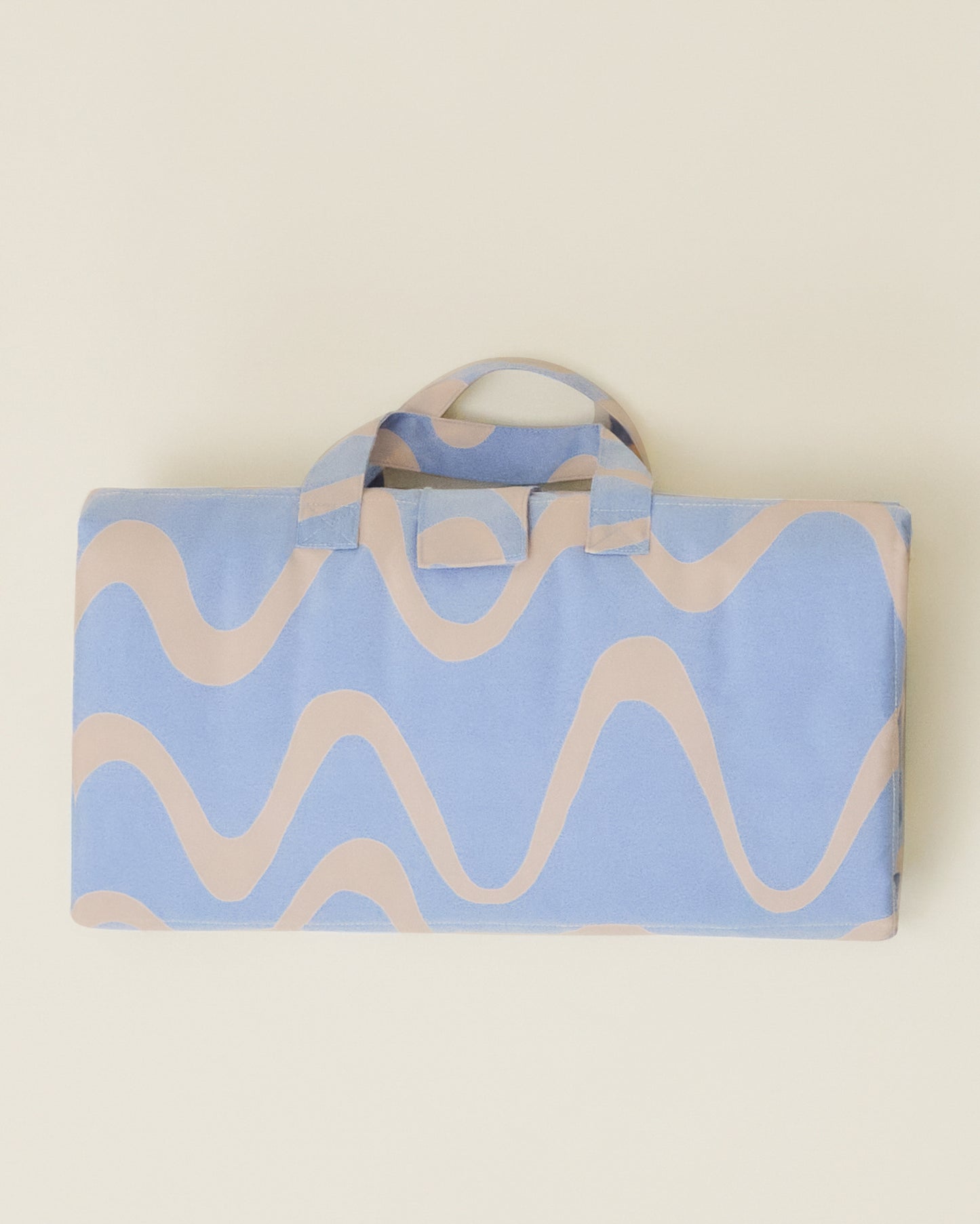 The Inside/Outside Play Mat in Blue Waves print, folded into a neat rectangle with a handle.