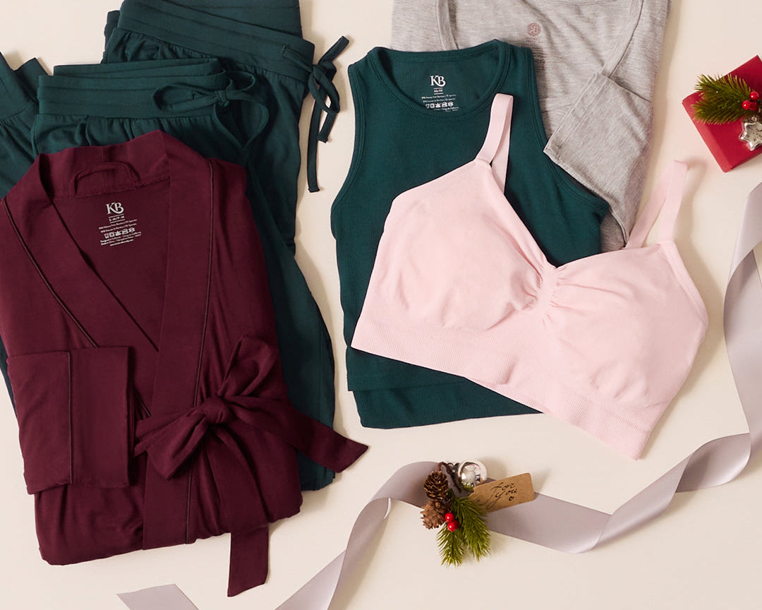 Laydown of women's clothing including a robe, tank top, and bra on a light background with decorative elements.