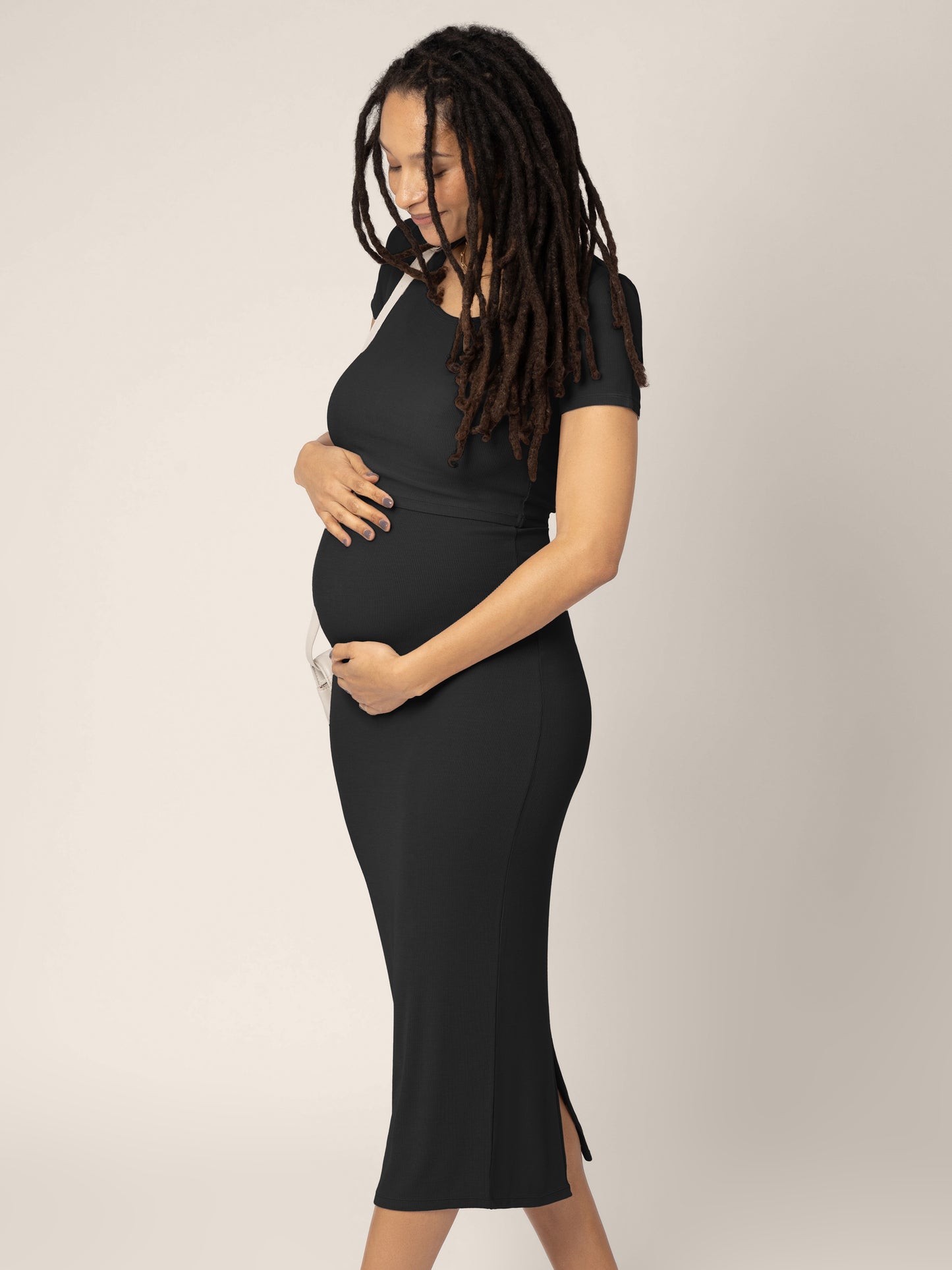Pregnant model wearing the Olivia Ribbed Bamboo 2-in-1 Maternity & Nursing Dress in black