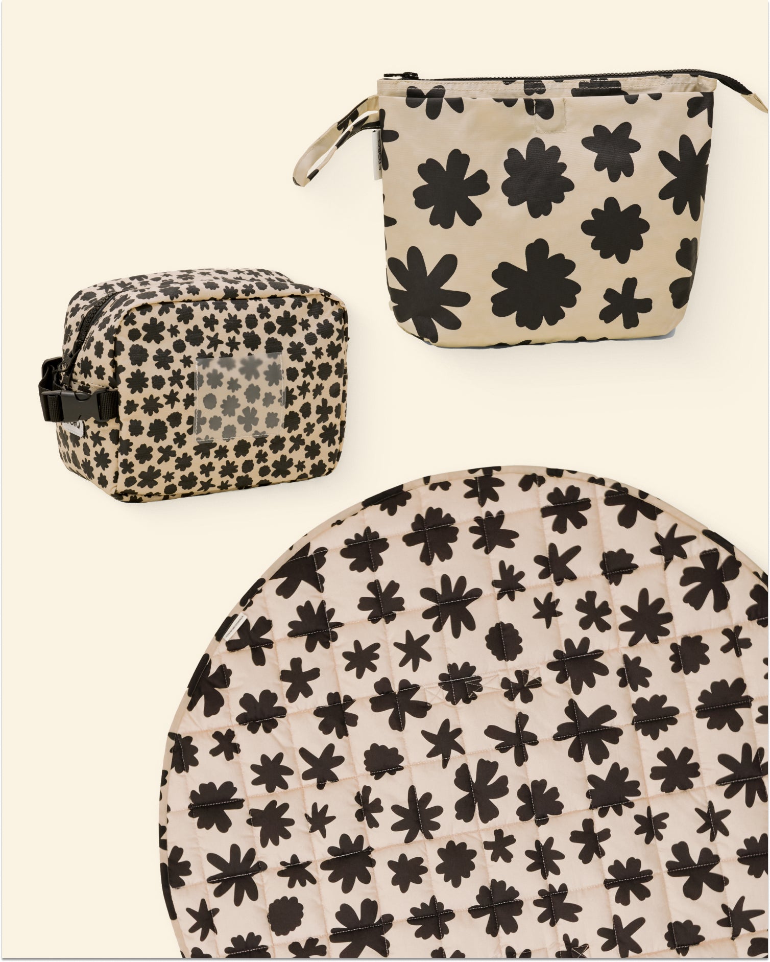 Set of cream and black floral patterned pouches and a play mat on a light background