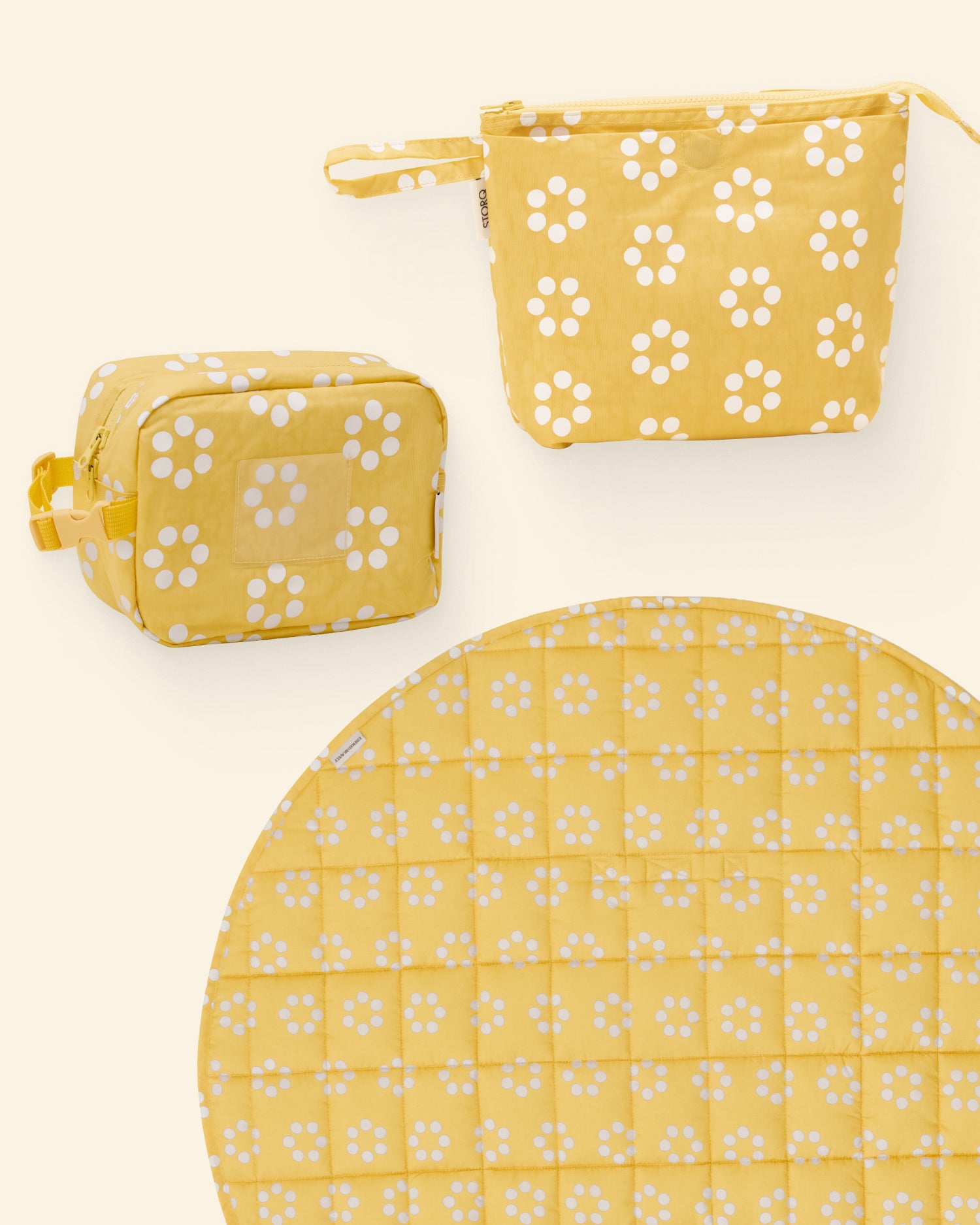 Set of yellow and white wave floral dot patterned pouches and a play mat on a light background