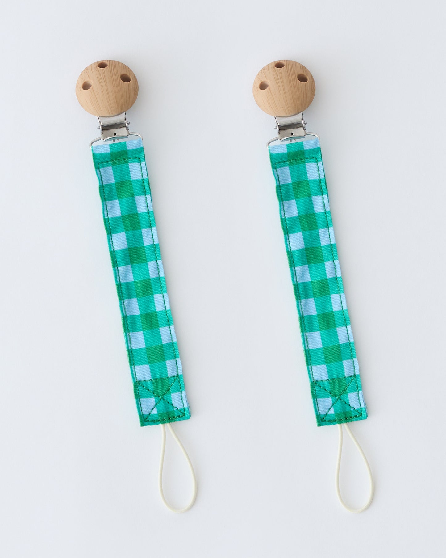 Pacifier Clip Two-Pack in Teal Gingham, on a beige background.