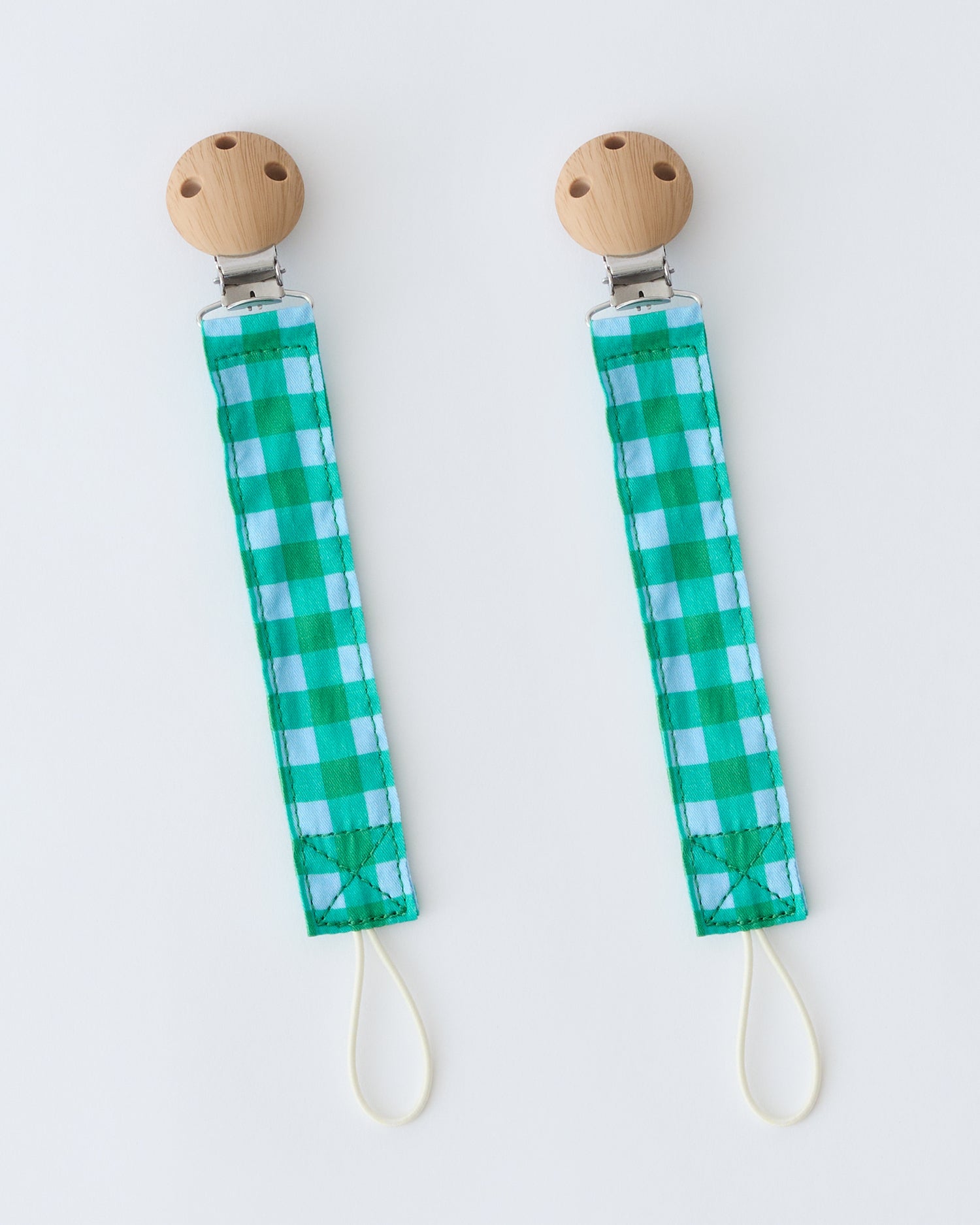 Pacifier Clip Two-Pack in Teal Gingham, on a beige background.