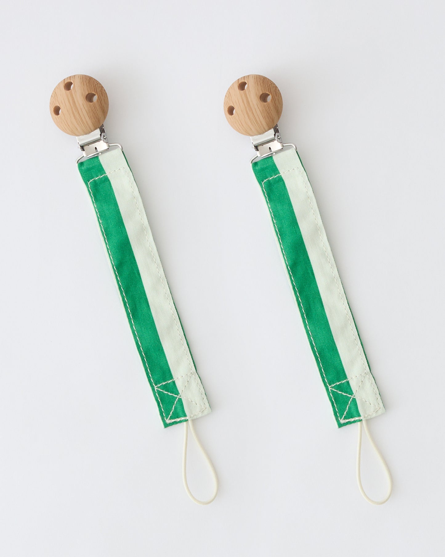 Pacifier Clip Two-Pack in Green Stripe, on a beige background.