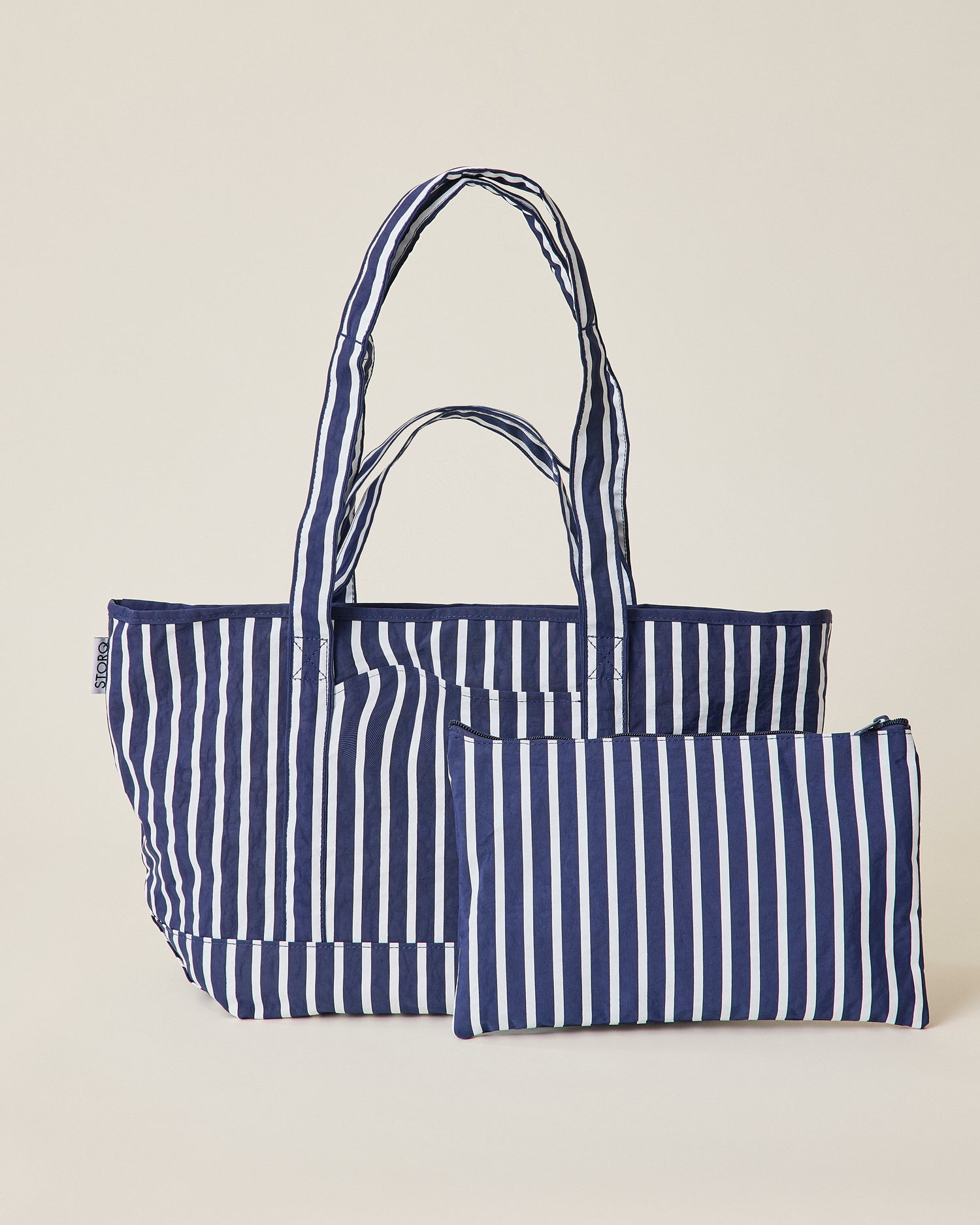 Navy blue and white striped Packable Park Carryall with included matching pouch on a beige background