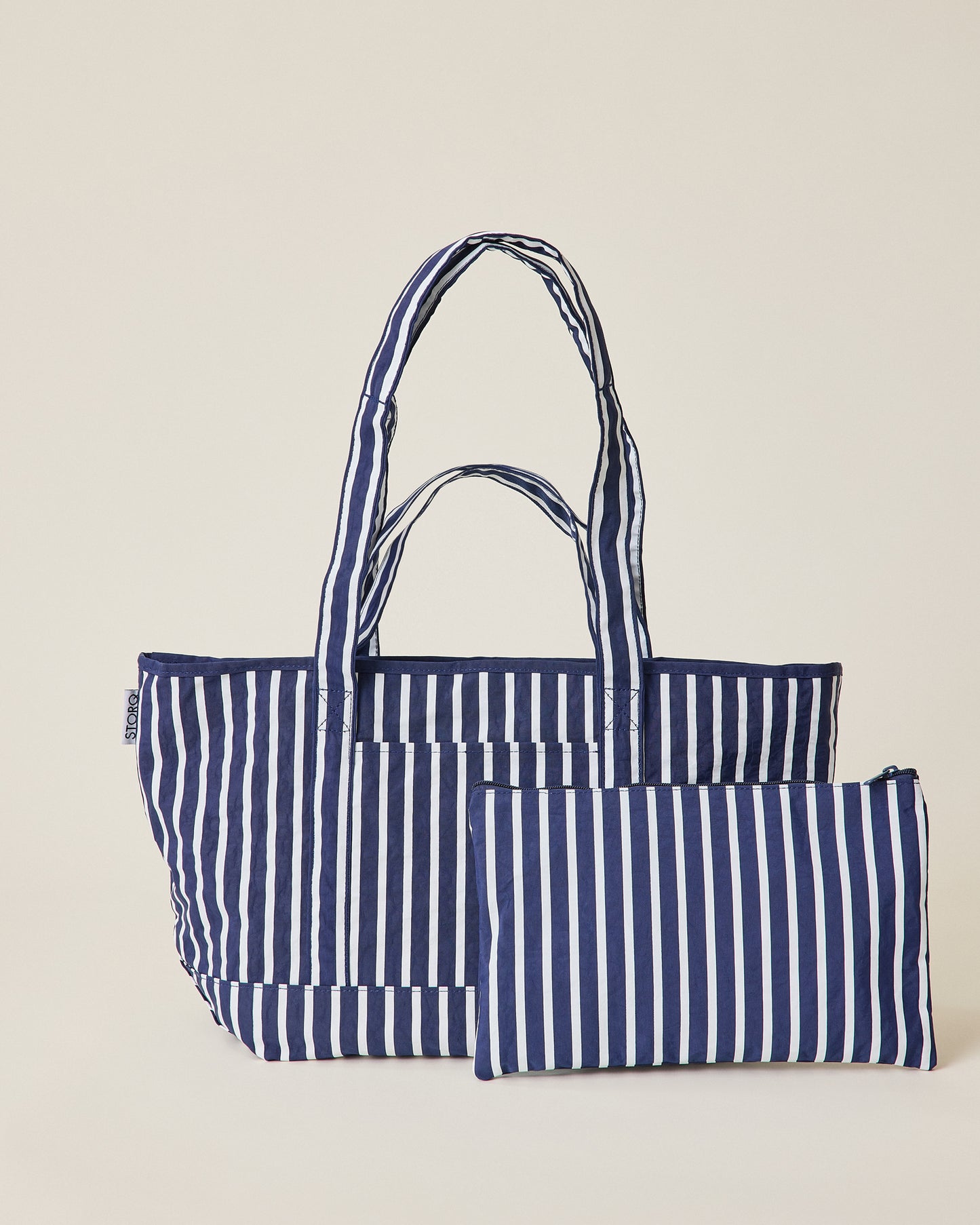 Navy blue and white striped Packable Park Carryall with included matching pouch on a beige background