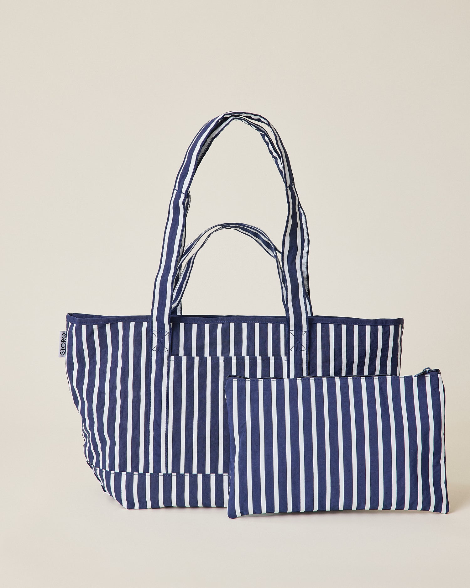 Navy blue and white striped Packable Park Carryall with included matching pouch on a beige background