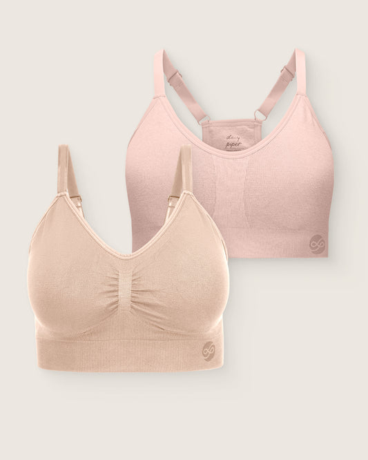 Two bras, one pink and one beige, on a light gray background