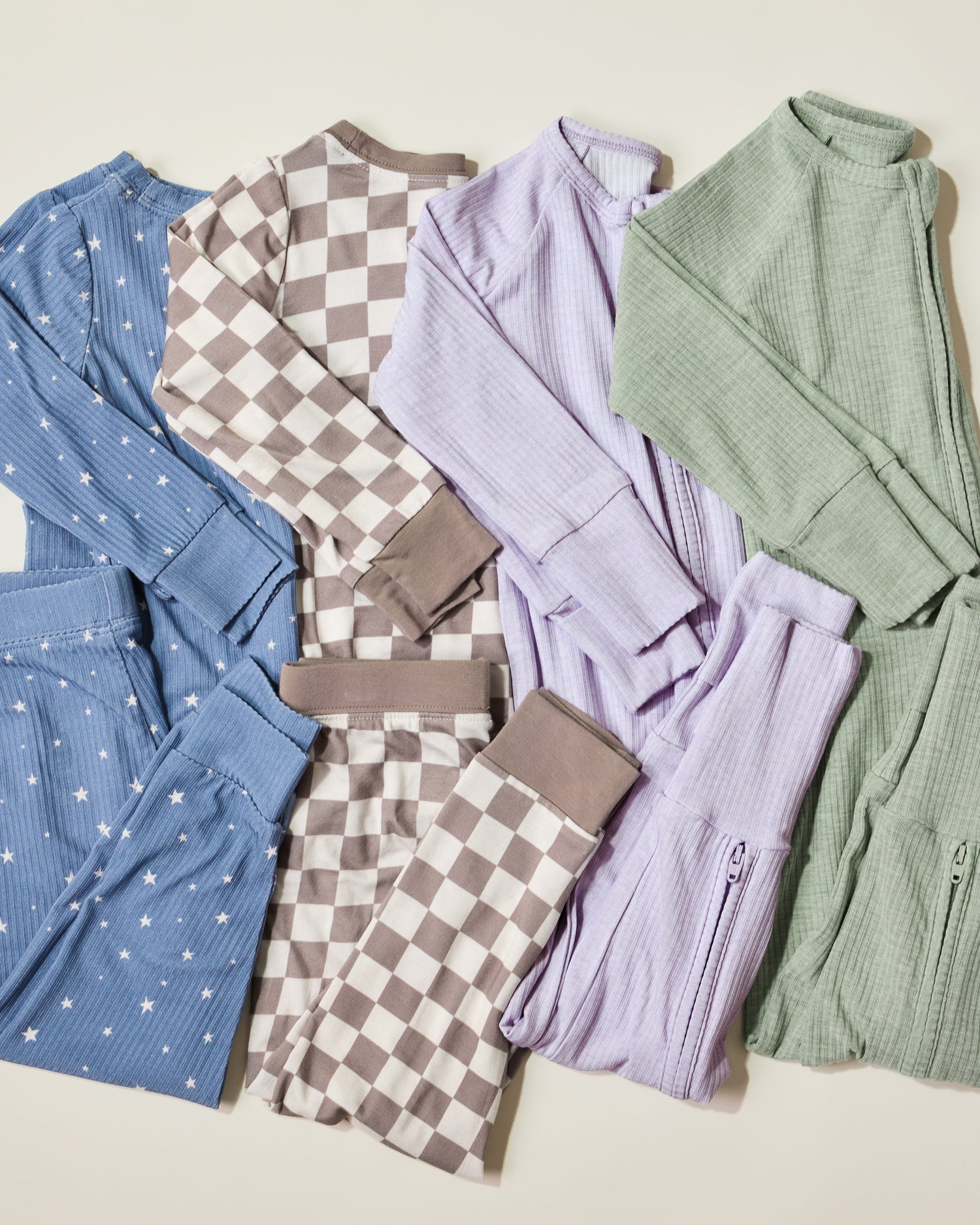 Collection of various baby pajamas on a light background