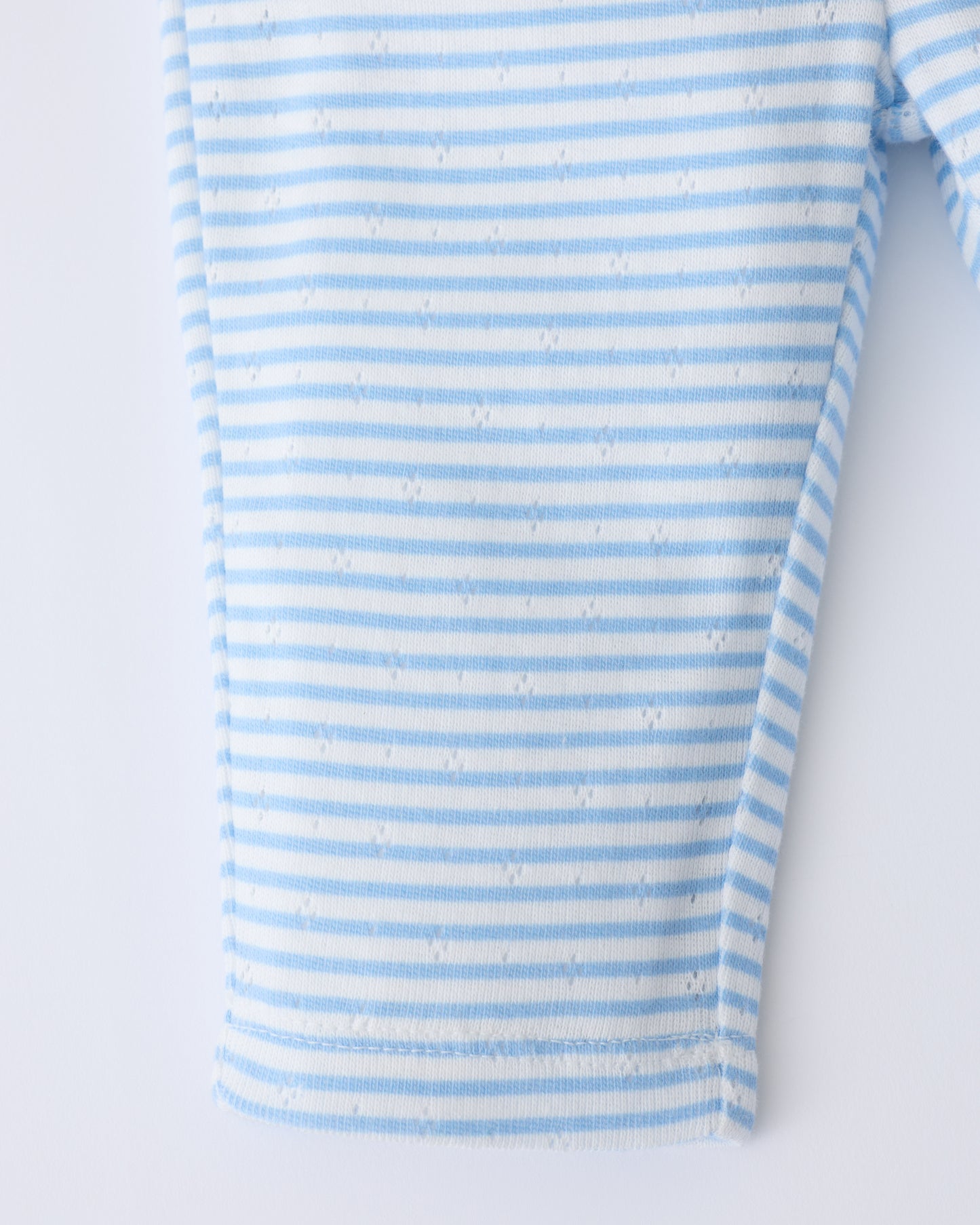 Close up of leg detail on the Pointelle Leggings in Blue Candy Stripe on a beige background.