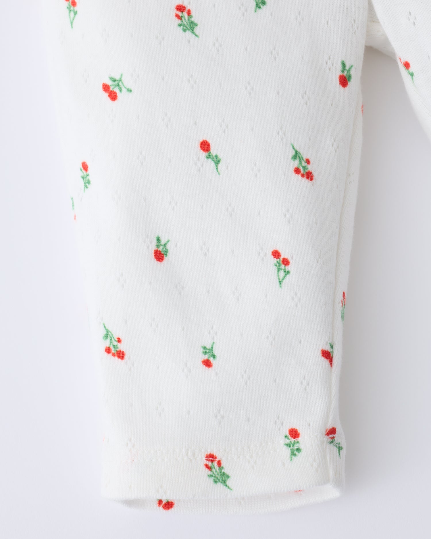 Close up of the leg detail on Pointelle Leggings in Dainty Ditsy pattern on a beige background.