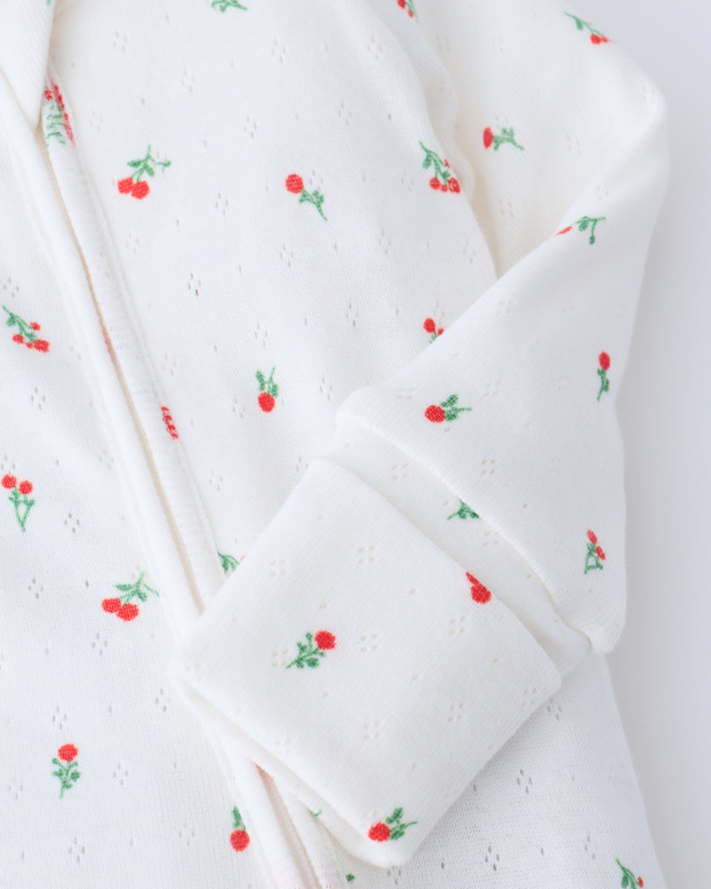 Close up of sleeve detail on Pointelle Sleeper Pajama in Dainty Ditsy on a beige background.