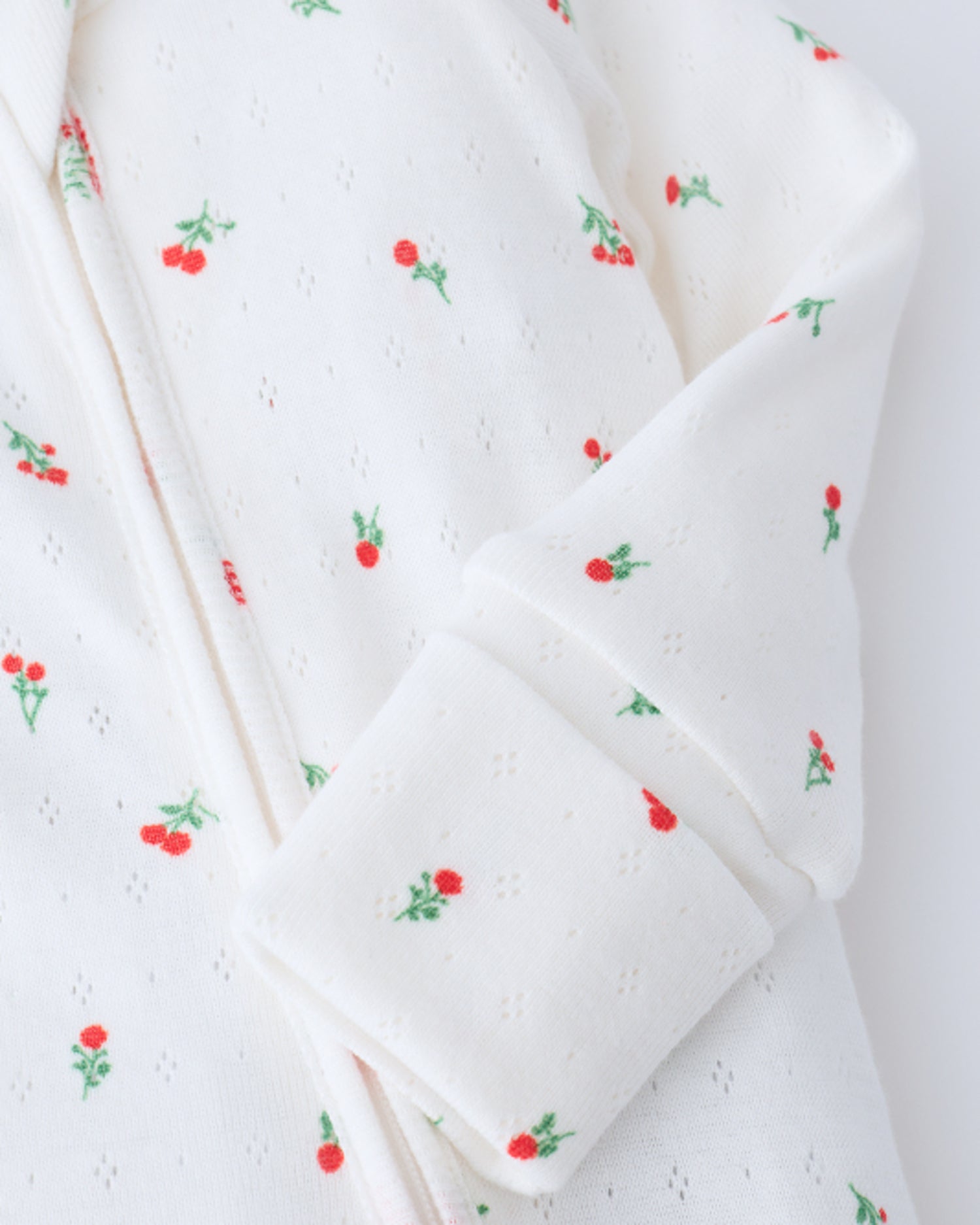 Close up of sleeve detail on Pointelle Sleeper Pajama in Dainty Ditsy on a beige background.