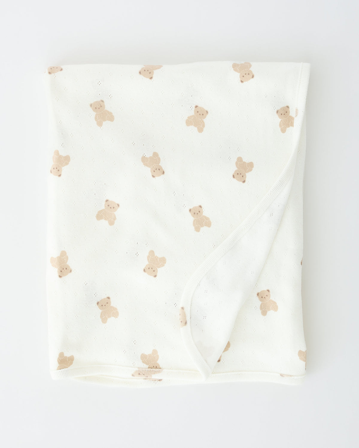Pointelle Swaddle Blanket in Ivory Bears folded up on an off white background.