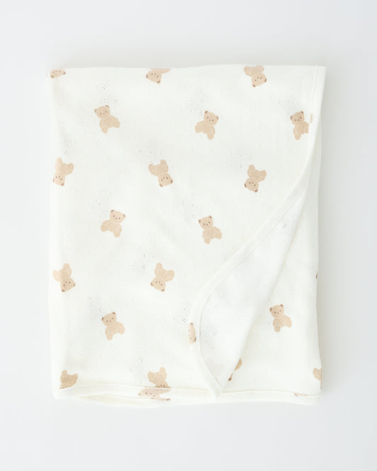 Pointelle Swaddle Blanket in Ivory Bears folded up on an off white background.