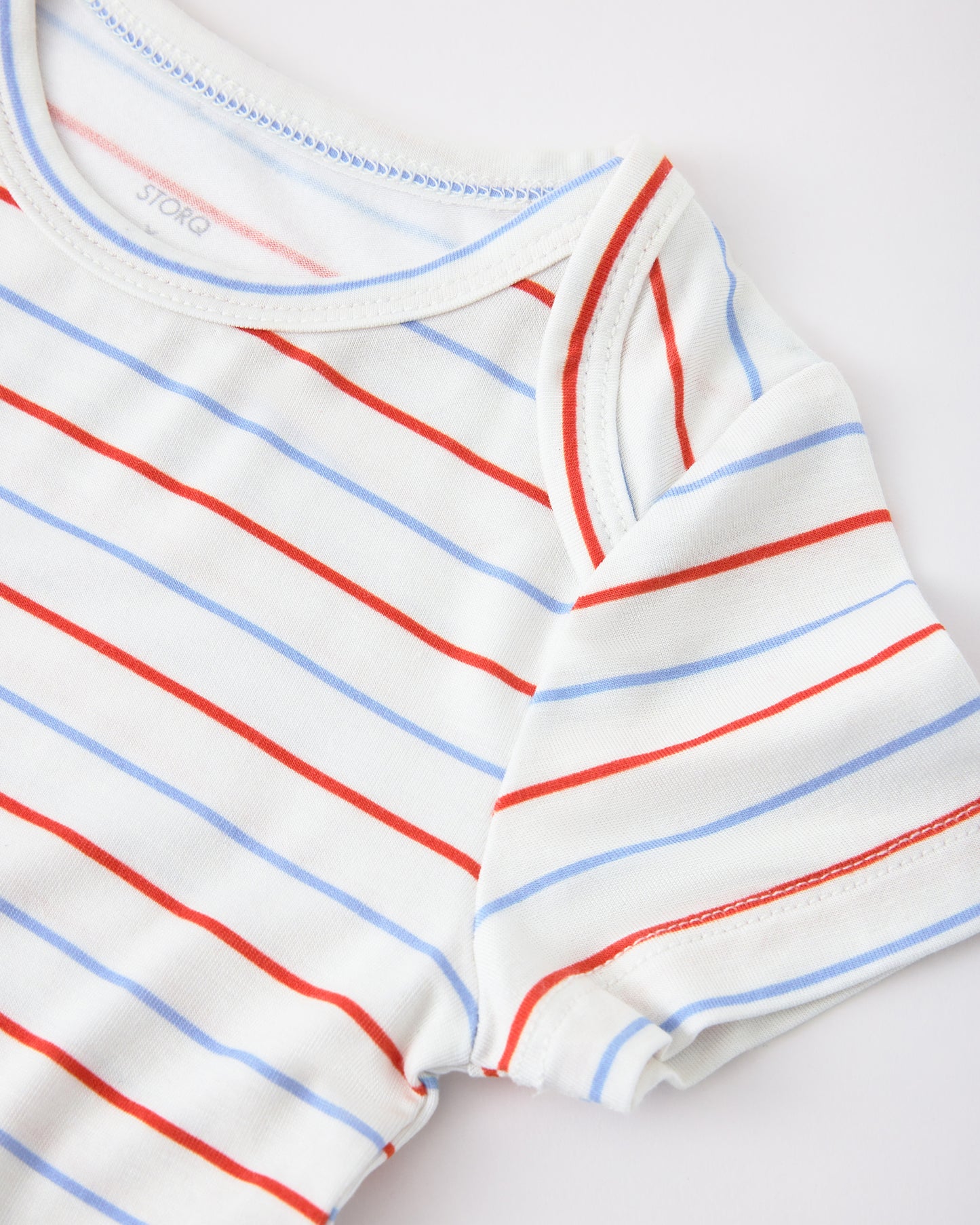 Close up of sleeve detail on Baby Onesie Two-Pack in Milk Please on a beige background
