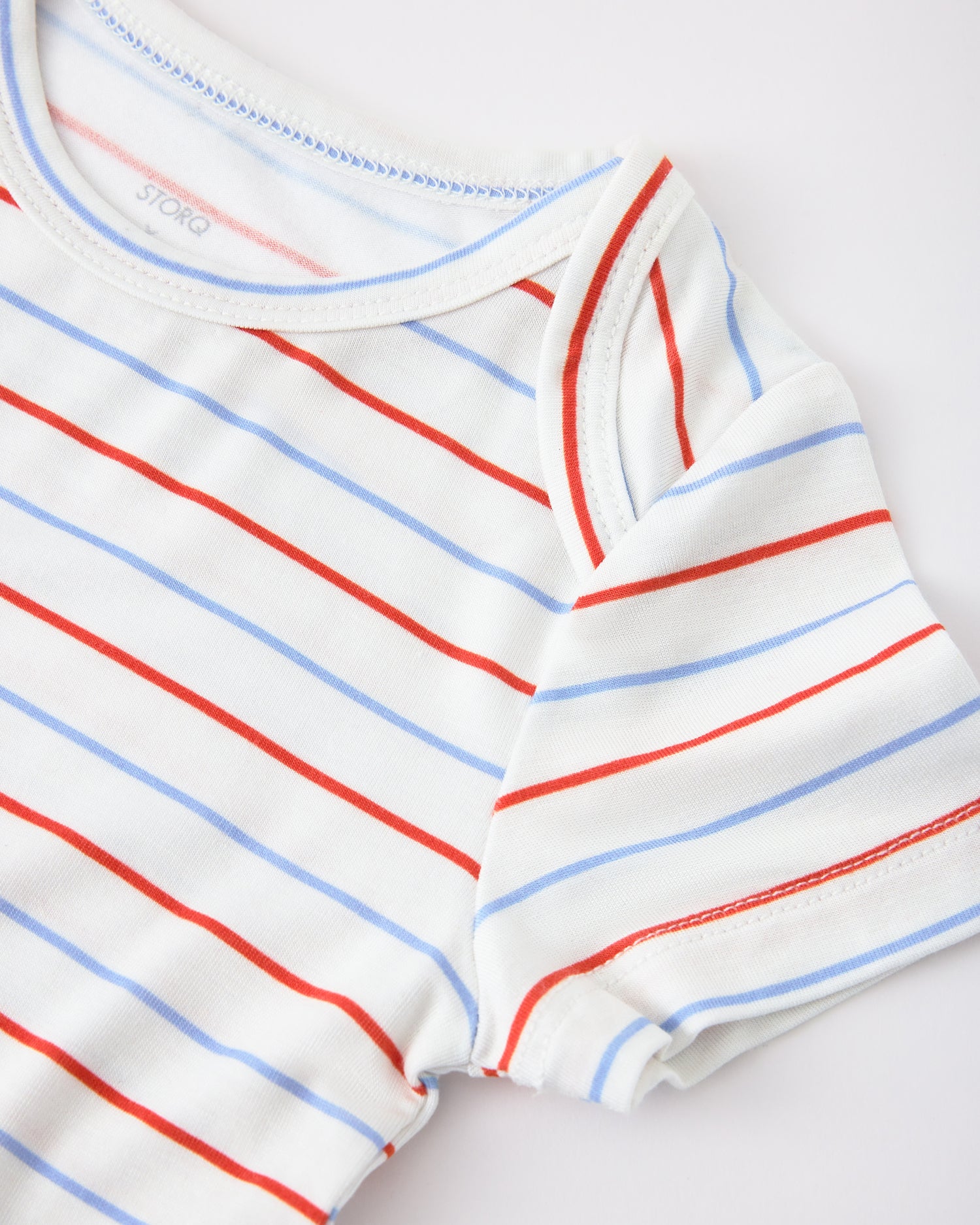 Close up of sleeve detail on Baby Onesie Two-Pack in Milk Please on a beige background