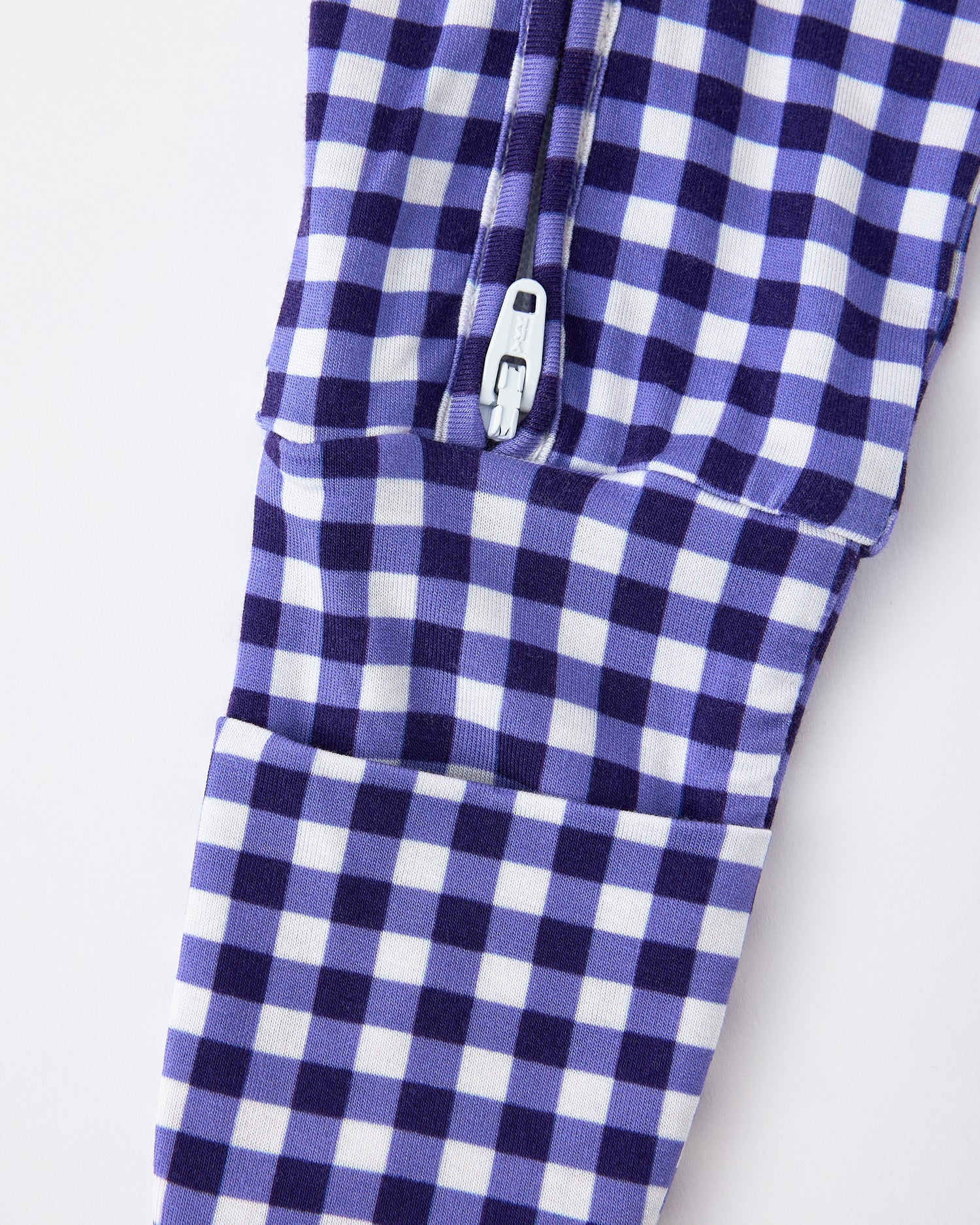 Close up of pant zipper detail of the Bamboo Baby Pajama in Blue Gingham on a beige background