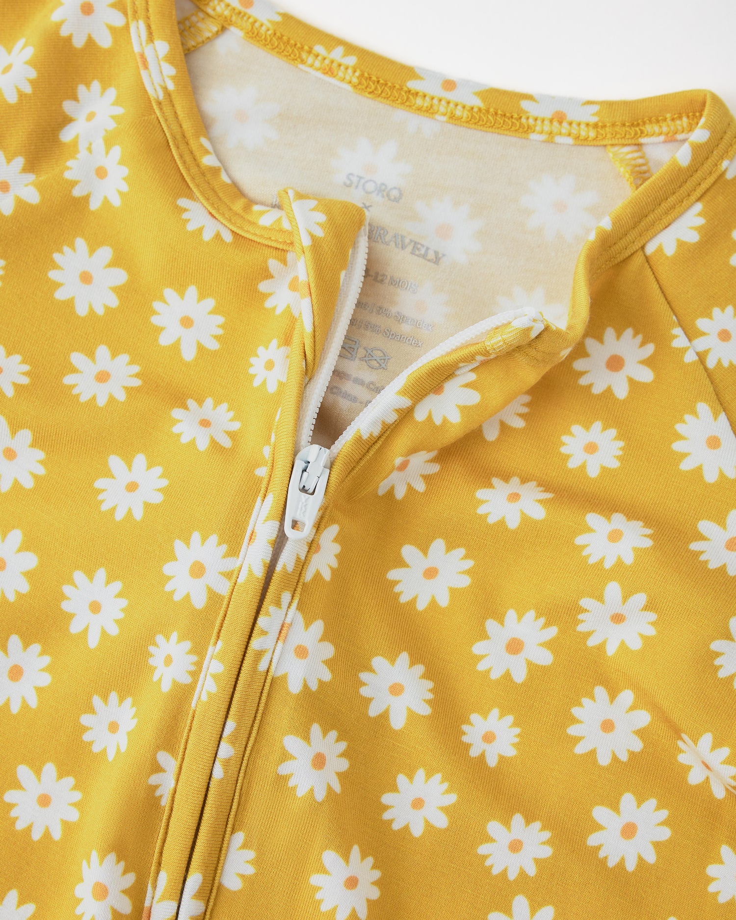 Close up of collar and zipper detail of Bamboo Baby Pajama in Yellow Daisies on a beige background