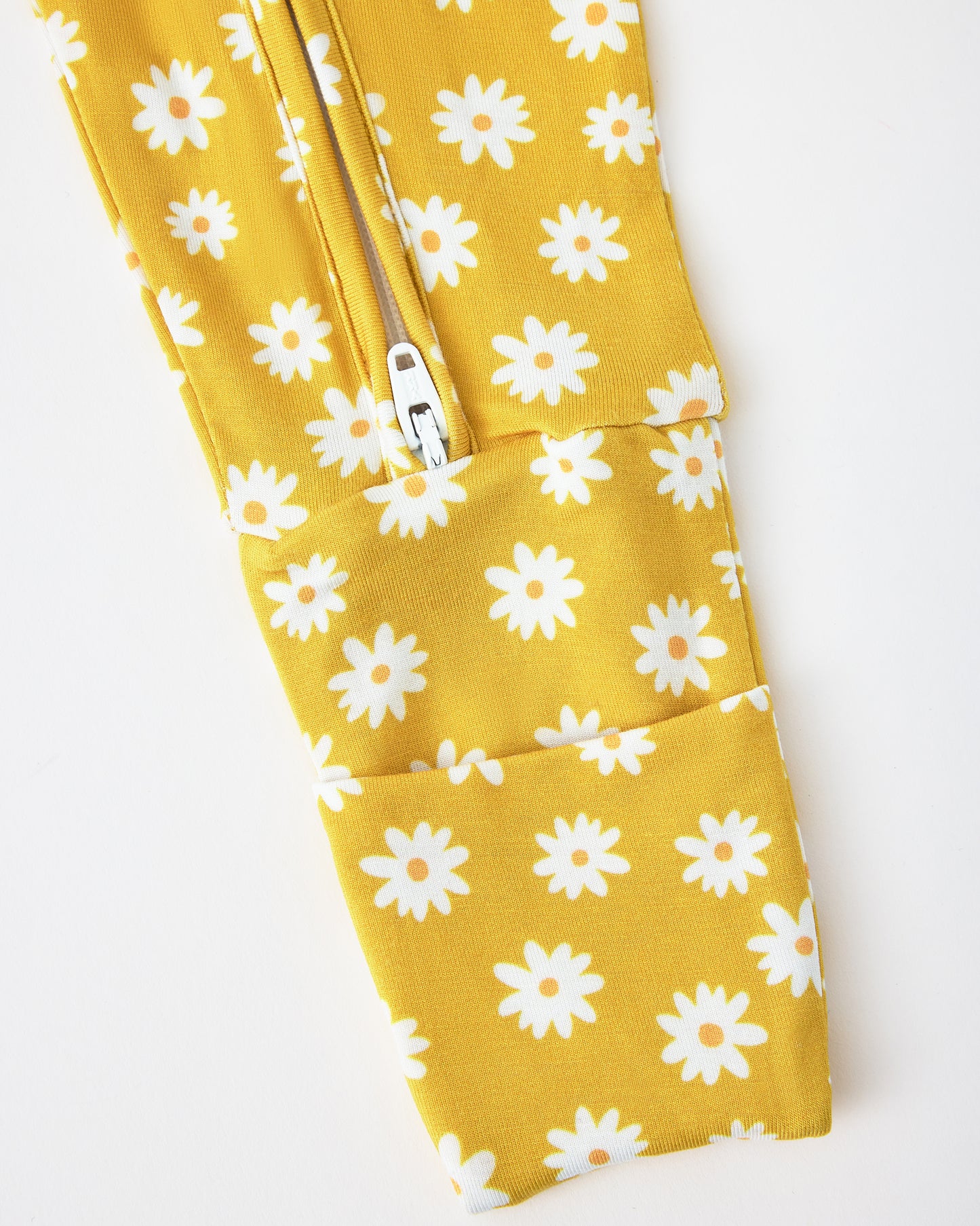 Close up of pant zipper detail of Bamboo Baby Pajama in Yellow Daisies on a beige background