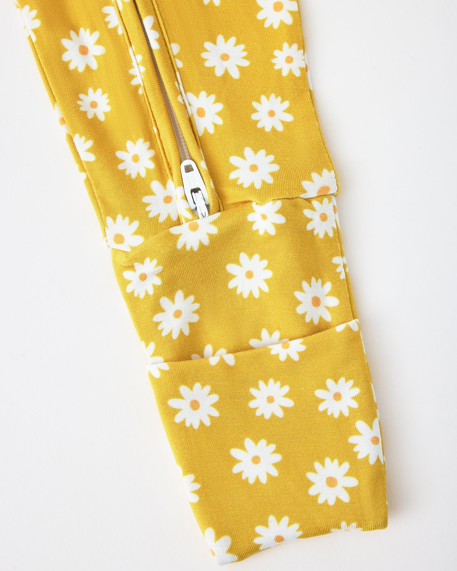 Close up of pant zipper detail of Bamboo Baby Pajama in Yellow Daisies on a beige background
