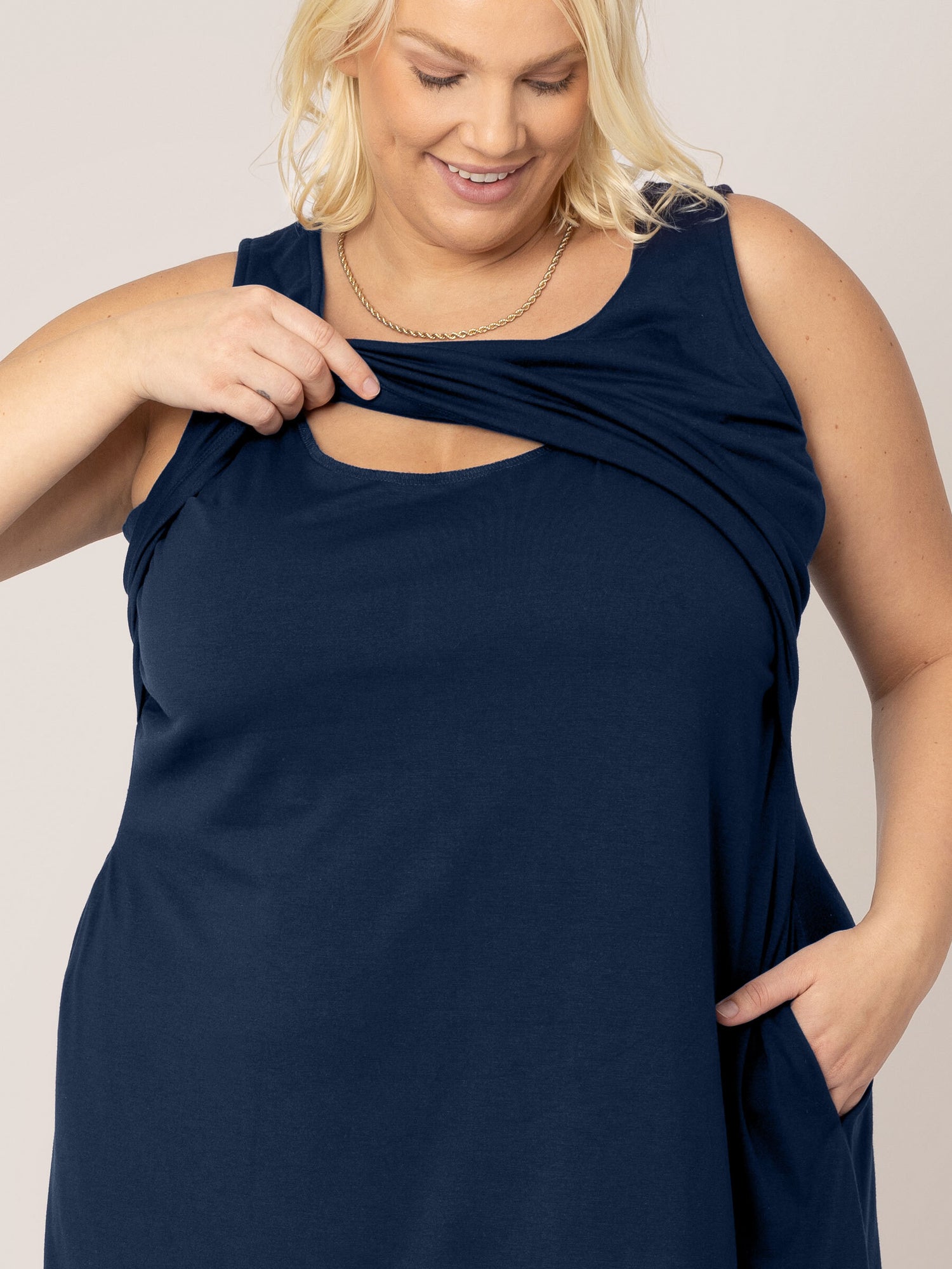 Model wearing the Penelope Crossover Nursing Dress in navy with focus on the nursing access