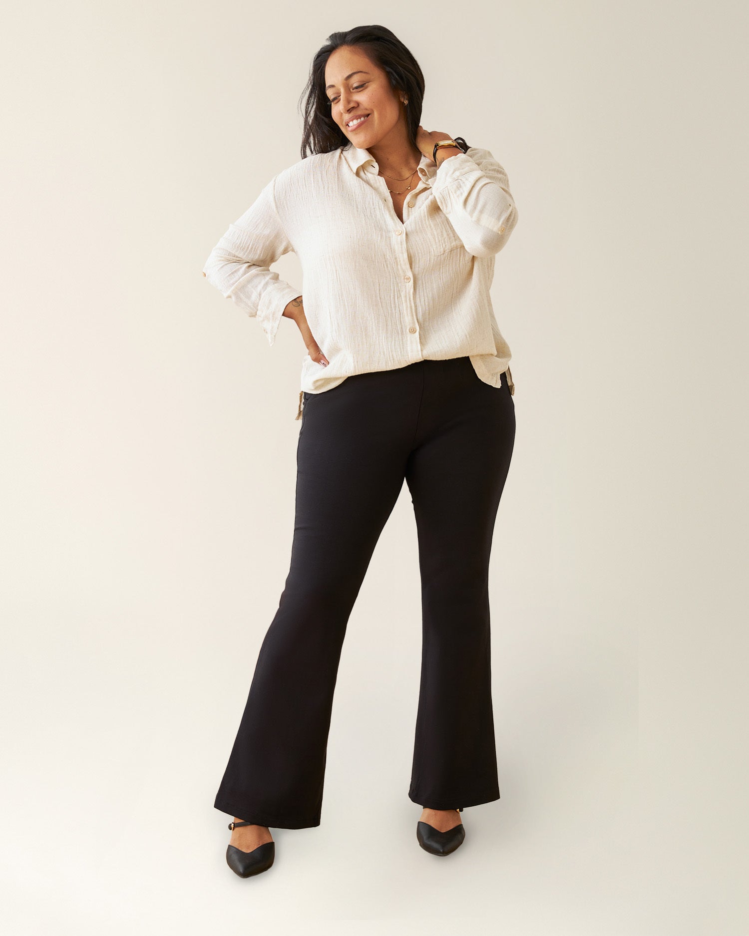 Woman wearing the Ponte Flare Pant with a button up top