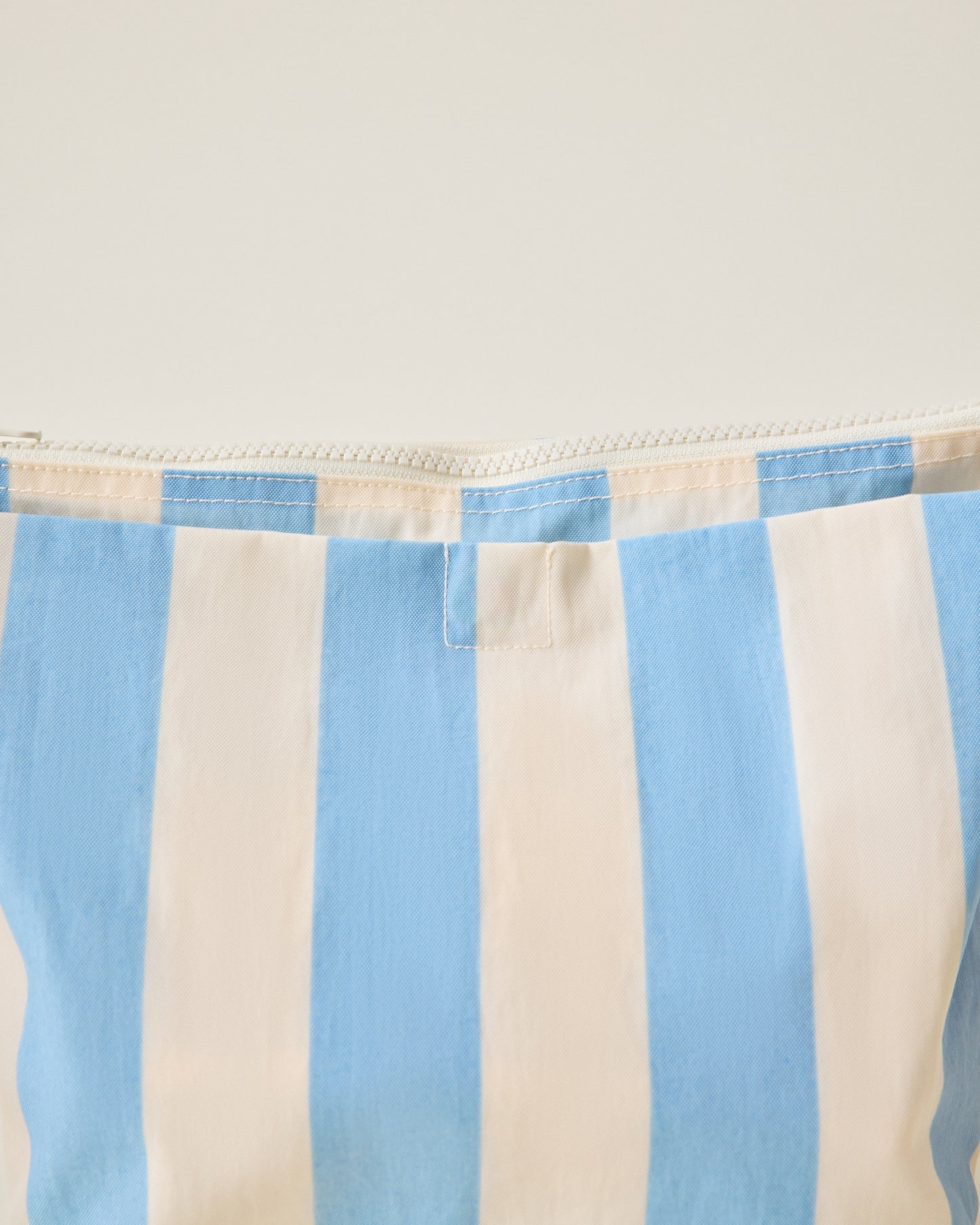 Quick Change Kit Bag in Blue Wide Stripe pattern detail view on a beige background