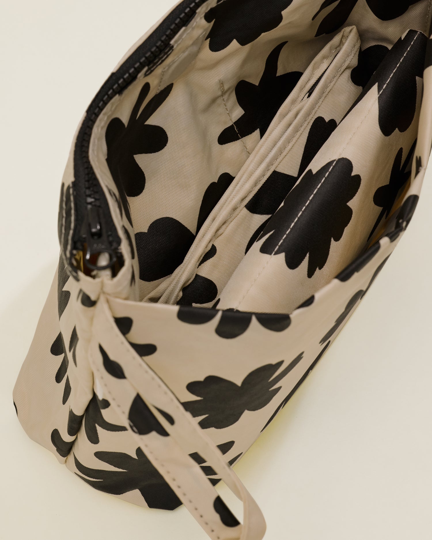 Close up of Quick Change Kit Bag in Cream Chamomiles print, showing the folded changing pad inside