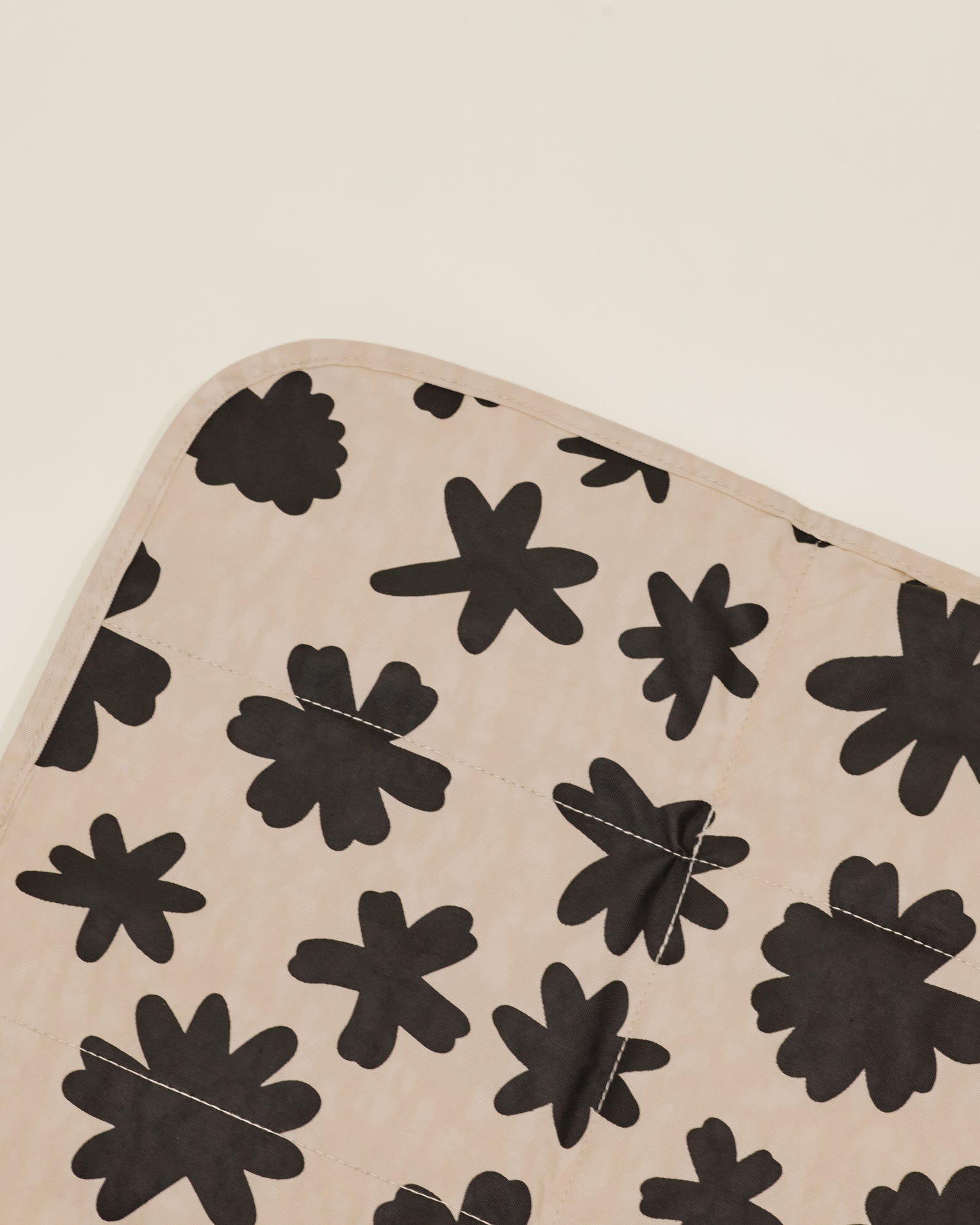 Close up of Quick Change Kit Bag in Cream Chamomiles print, showing the folded changing pad inside