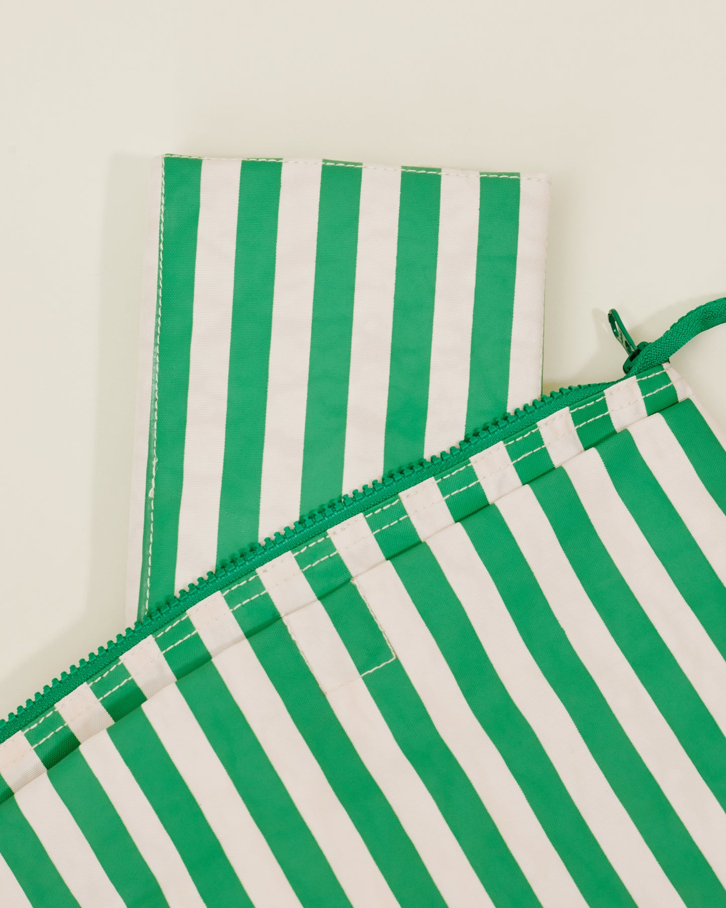 Close up of Quick Change Kit Bag in Green Stripe print, showing the folded changing pad