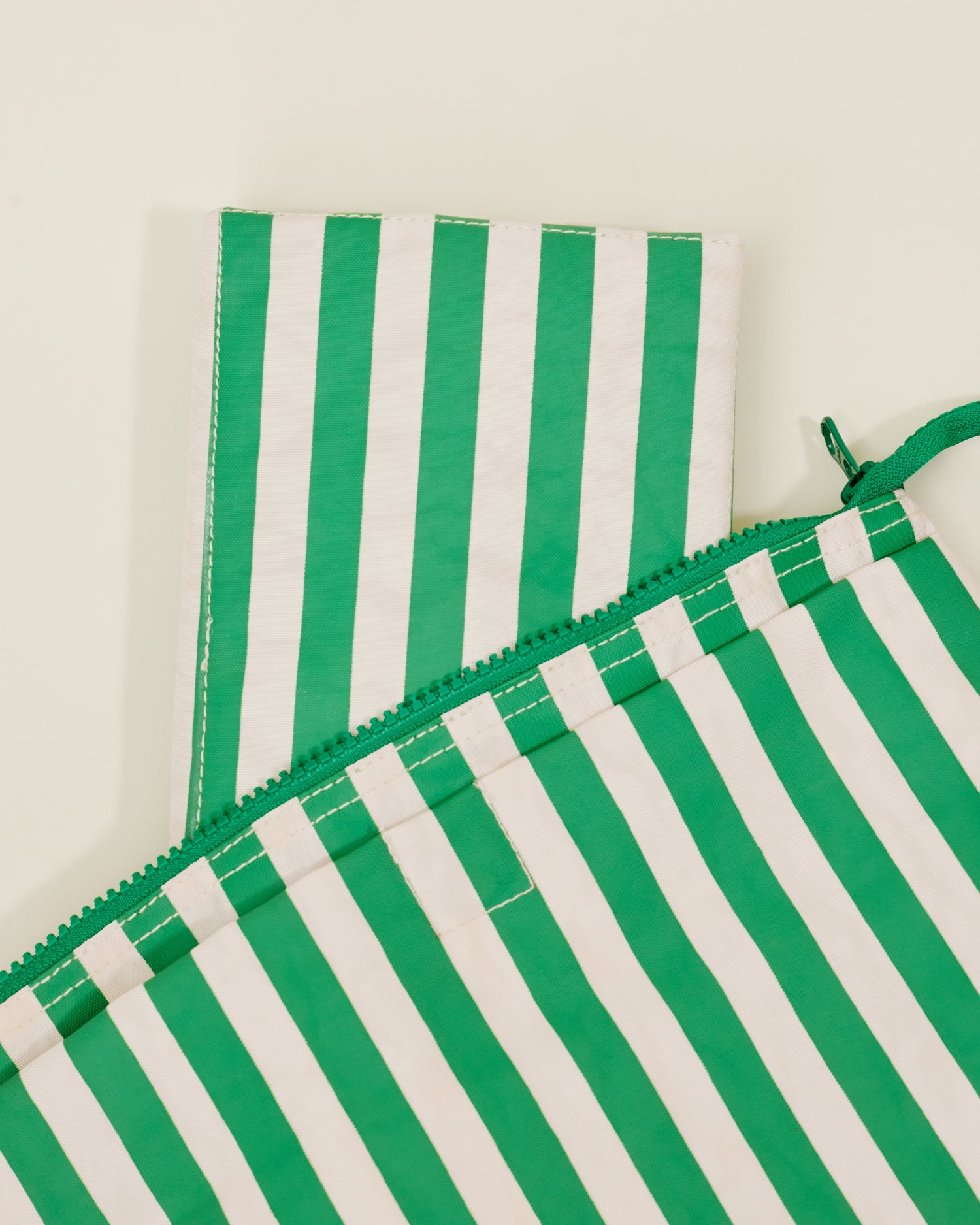 Close up of Quick Change Kit Bag in Green Stripe print, showing the folded changing pad