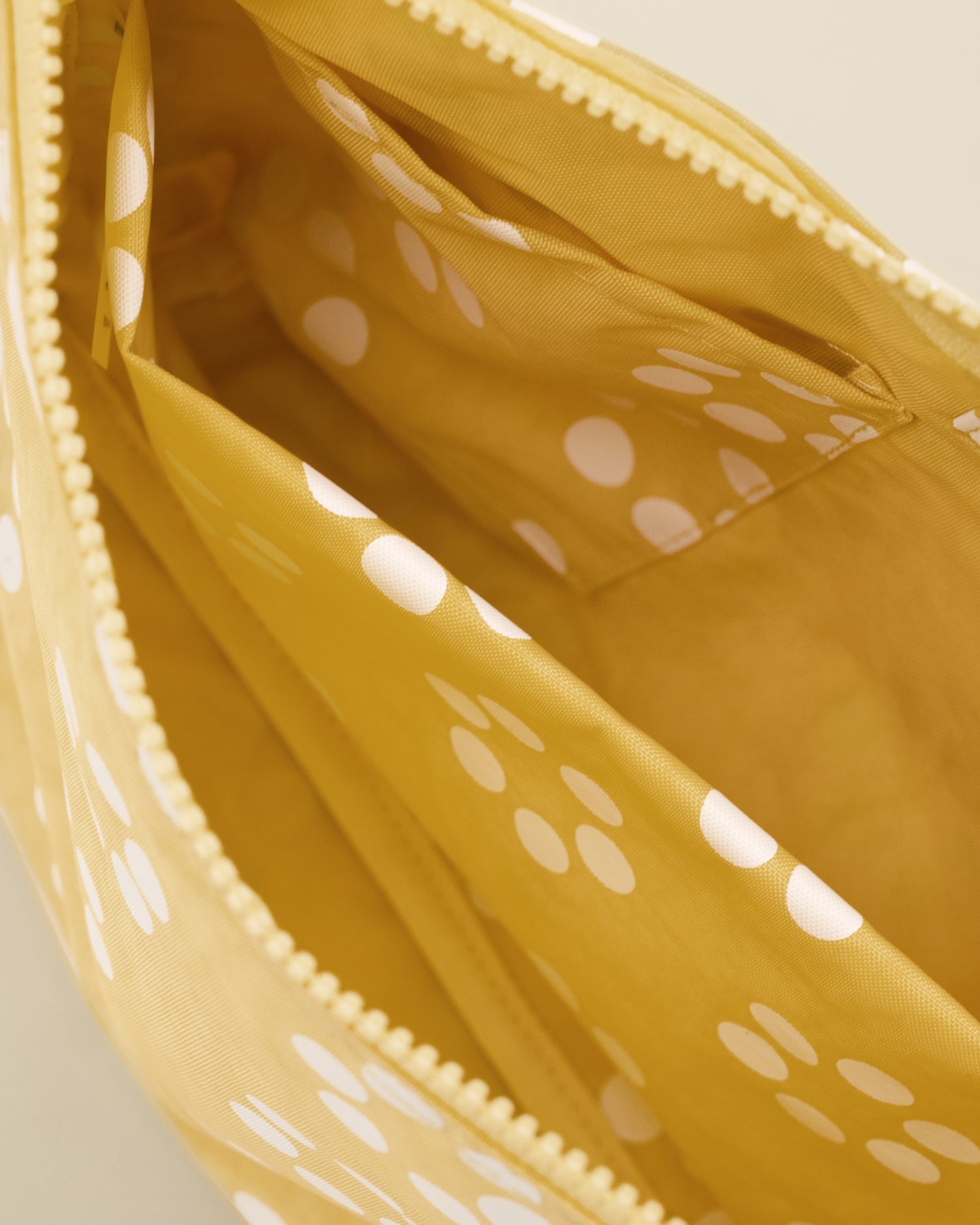 Close up of Quick Change Kit Bag in Sunshine Dots print, showing the inside of the bag