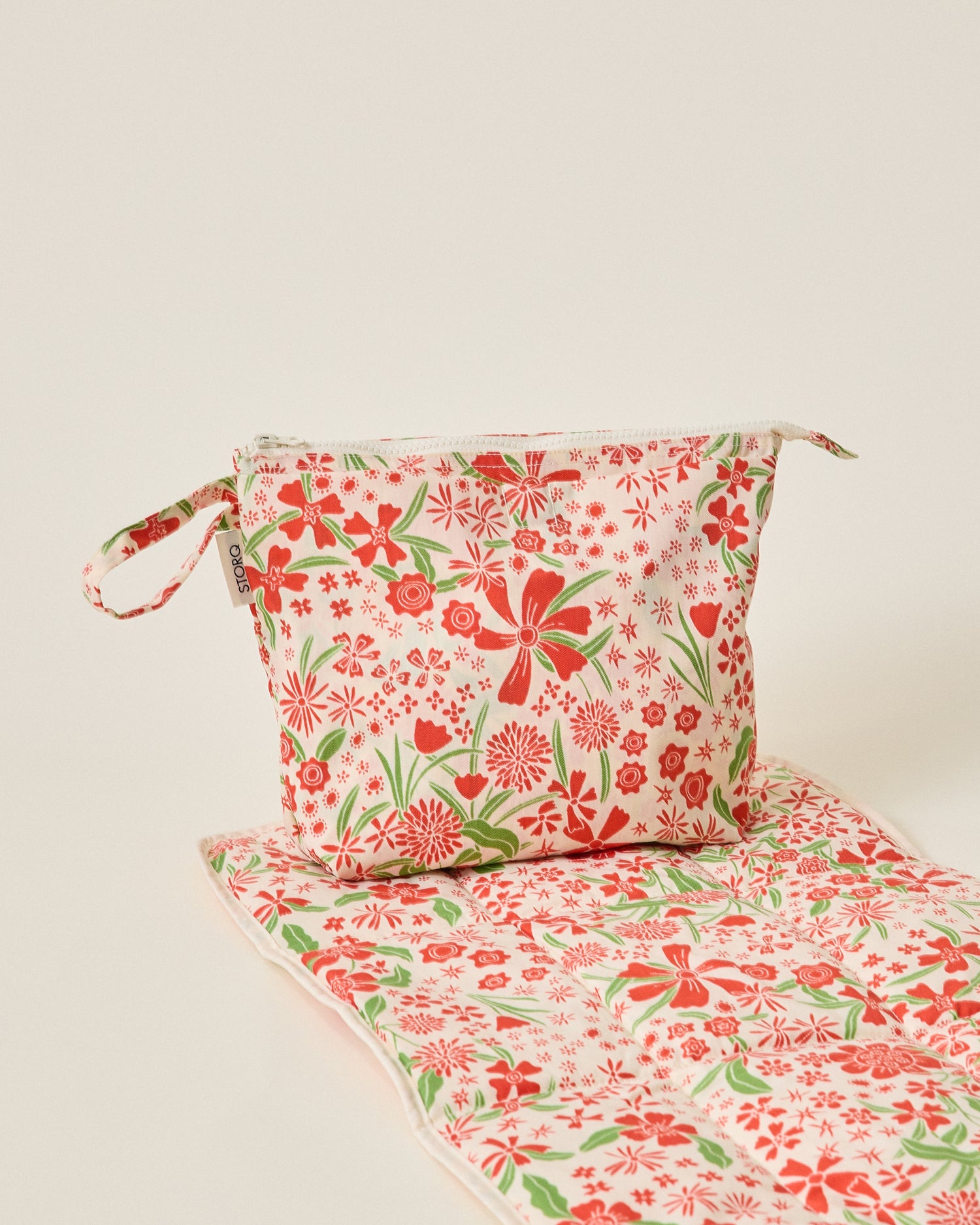 Quick Change Kit Bag and mat in Superbloom on a beige background