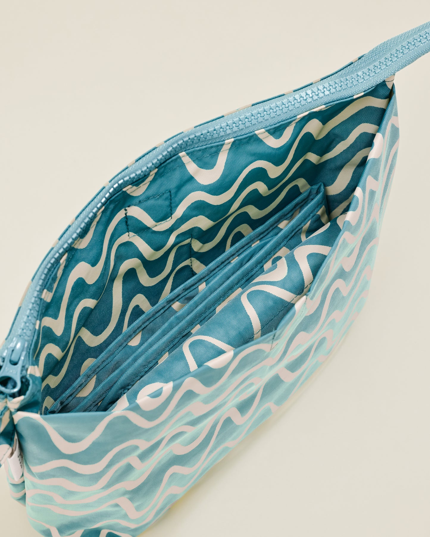 Close up of Quick Change Kit Bag in Blue Waves print, showing the changing pad inside the bag