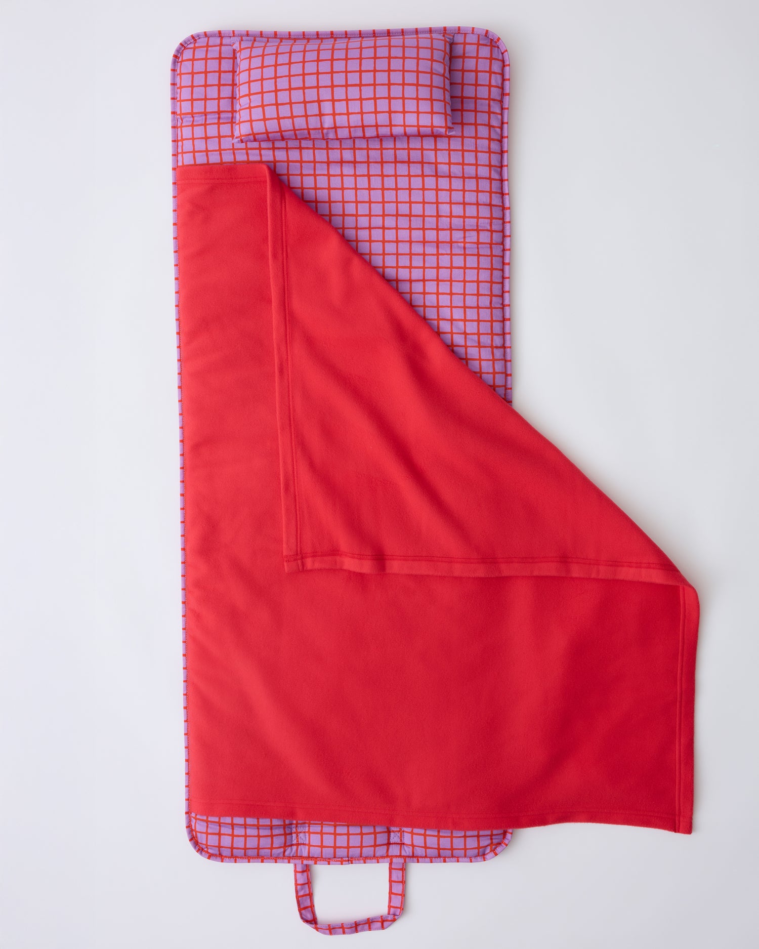 Open flat lay Cool Kid Nap Mat in Orchid Grid on a beige background.