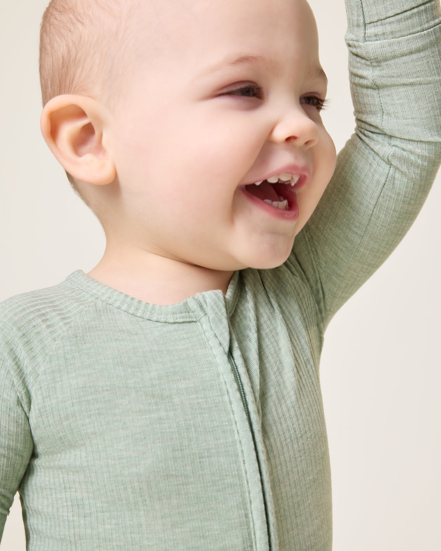 Baby laughing wearing the Ribbed Bamboo Baby Pajama in Sage Heather