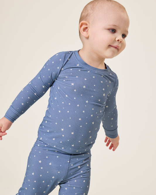 Baby wearing the Ribbed Bamboo Baby Two-Piece Pajama Set in Blue Stars@model_info:Clark is wearing 18-24 months.